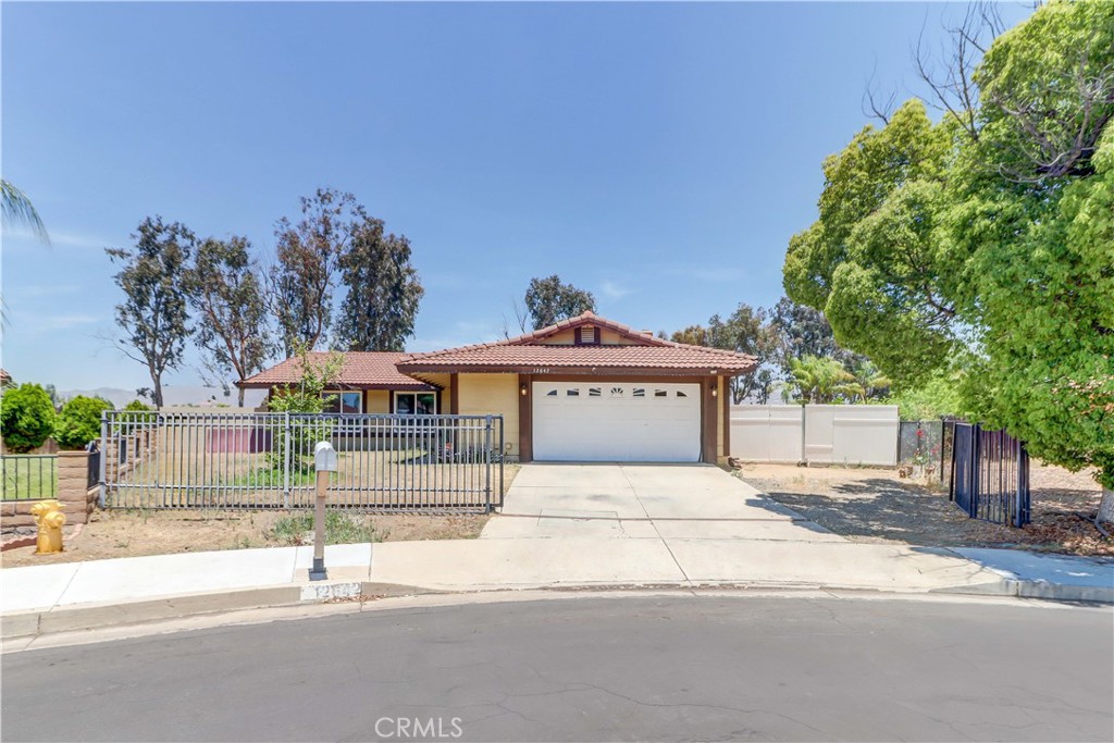 Discover the opportunities waiting for you within this striking 3-bedroom, 2-bath home set on a 13,000+ sq ft lot in Moreno Valley! A fenced yard and gated drive grant a sense of security to this single-story residence. Inside, vaulted ceilings rise above sunlit living and dining areas, where wide windows brighten tile flooring and a classic brick fireplace invites relaxed evenings.
The open kitchen is effortlessly functional, with stainless steel appliances, ample cabinetry, and textured countertops and backsplash. Each restful retreat offers ceiling fans and plush carpeting, including your primary suite with its direct patio access and a convenient ensuite. Imagine transforming the sprawling backyard into your own personal oasis by building an ADU, creating an outdoor entertainment hub, planning a garden, or installing a pool.
Additional perks include a laundry room with storage, an attached 2-car garage with direct-entry, and close proximity to a vast array of shopping options, March Air Reserve Base, the I-215, and the 60 Fwy. Whether expanding your lifestyle or planting new roots, come let the possibilities unfold!