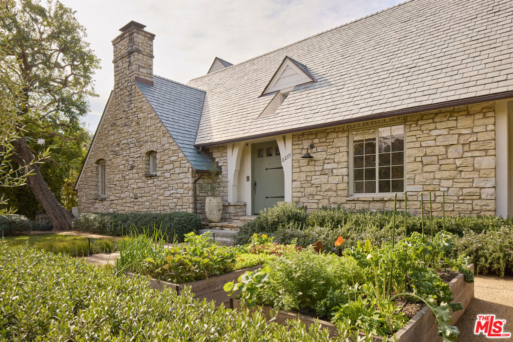 A Storybook Retreat in Lower Mandeville Canyon. Nestled behind gates in coveted Lower Mandeville Canyon, this exquisitely restored English country cottage seamlessly blends classic elegance with contemporary luxury. Surrounded by mature olive trees, meandering gravel paths, and lush landscaping, the nearly half-acre property offers a private sanctuary of unparalleled refinement. Meticulously updated, the five-bedroom, five-bathroom home features a fully reimagined kitchen with hand-selected stone flooring, all-new appliances, and bespoke fixtures. Light pours through vaulted ceilings in the exquisite living room and upstairs bonus room. Every detail has been thoughtfully curated from rich oak flooring and custom wall coverings to designer lighting creating a home that harmoniously balances original character with impeccable modern sophistication.The exterior is just as captivating. A flourishing organic vegetable garden graces the front, while the expansive backyard boasts a covered pool and spa, a large grassy lawn, and a fully equipped outdoor kitchen an idyllic retreat for relaxation and entertaining. Beneath a striking new slate roof with copper gutters, the home is as technically advanced as it is visually stunning. A new HVAC system, tankless water heaters, a whole-house generator, and a state-of-the-art security system ensure effortless comfort and peace of mind. Set within one of Brentwood's most desirable enclaves, this rare gem embodies privacy, sophistication, and timeless beauty. Fireplace are decorative only.