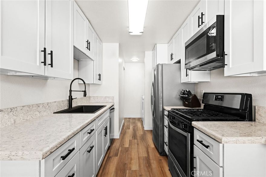 Welcome home to this beautifully upgraded upper unit condo in the Aliso Villas 2 community of Mission Viejo, featuring two bedrooms and two bathrooms, having been converted from a shared bath to two separate ones—one full and one three-quarter—upgraded in 2024. Enjoy the privacy of no neighbors above or below, along with a spacious balcony perfect for patio seating. Inside, you'll find newer LVP flooring, dual-pane windows, and a remodeled kitchen with white cabinetry, black hardware, stainless steel appliances, quartz countertops, and a built-in bar counter. The family room boasts recessed lighting and a cozy fireplace, while the primary suite includes a barn door, dual vanities, and a walk-in shower. Additional features include a secondary bedroom, an upgraded guest bath, a newer HVAC system, newer roof, a one-car garage, an assigned parking space, and access to a community pool.