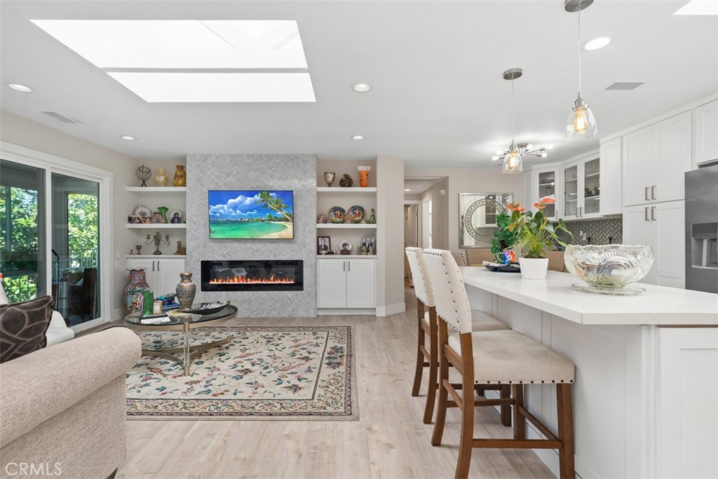 GORGEOUS home in the premier community of Laguna Woods Village has been completely remodeled. No expense spared for this Casa Linda floor plan. There are no stairs leading from the nearby carport and no residences above the unit. The home only shares one common wall with neighbors offering additional privacy. Newer flooring throughout with tasteful tile/stone work within the bathrooms. There are quartz counters, stainless steel appliances and newer cabinetry in both the kitchen and bathrooms. Custom built-in entertainment center includes an electric fireplace, a flat screen TV to rest above and bookshelves with cabinets on either side. The master bedroom includes a walk-in closet, a master bathroom with a generously sized shower. The home includes a washer/dryer, 3 newer skylights, newer solar tubes, recessed lights and a newer central cooling and heating system. There is a private enclosed balcony with porcelain tiling overlooking the neighborhood. Laguna Woods Village is a thriving community with many activities to enrich your lifestyle! Living here is like belonging to a country club.