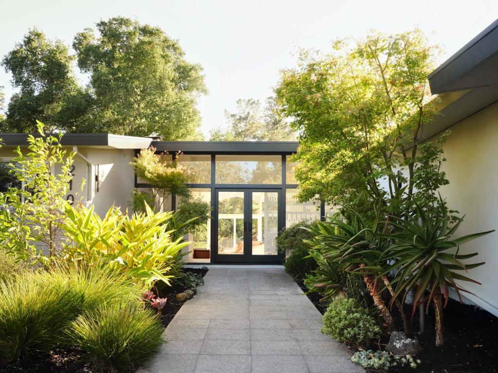 Reimagined by an award-winning interior designer, this serene hillside sanctuary with views to the Western Hills embodies quiet luxury through clean lines, layered textures, and refined finishes. Set on over 1.5 acres, the newly remodeled residence spans nearly 3,000 square feet and offers 5 spacious bedrooms, featuring a private in-law suite, and 4 tastefully appointed bathrooms.  Extensive upgrades include new bathrooms, windows, front and sliding glass doors, lighting, laundry room, full house electrical wiring, shed and a modernized kitchen. Inside, soaring ceilings and a dramatic wall of glass dissolve the boundary between indoors and out, filling the formal, dining, and family spaces with natural light. The interiors extend effortlessly to an expansive wraparound deck, while oak-studded grounds provide a tranquil backdrop for al fresco gatherings. Enjoy quintessential Portola Valley living just minutes from Stanford University, top-rated schools, scenic trails, weekly farmers markets, and private swim and tennis clubs.   Floorplan and disclosures available at 210Cervantes.com