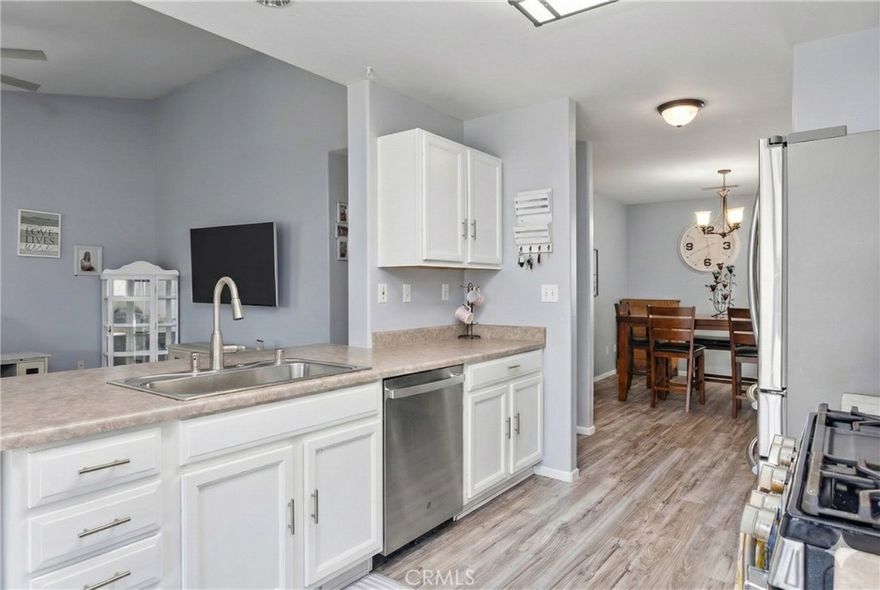 NW split-wing home offering 4B/2B and 1,843 sqft. of thoughtfully designed living space. Step inside to durable wood-look flooring and a bright, open kitchen featuring crisp white cabinetry, abundant storage, and appliances less than 2 years old. The formal dining room flows seamlessly into the kitchen, creating the ideal set-up for entertaining family and friends. A dedicated storage area helps keep your home organized, enhancing functionality. The backyard is built for relaxation and gatherings, boasting a spacious covered patio with recessed lighting and ceiling fans, plus a spa that stays with the property. Located near both elementary and high schools, this home blends comfort and convenience.