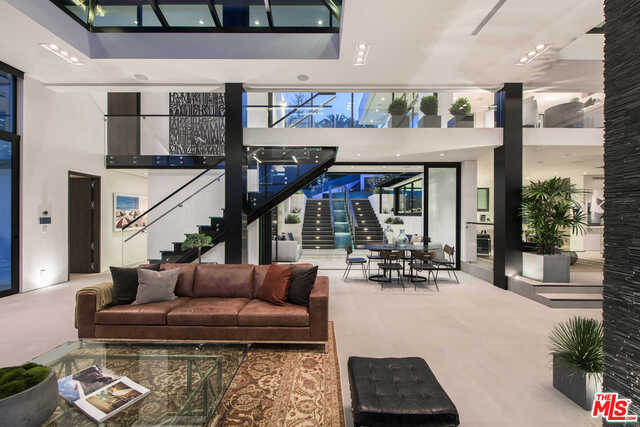 Think the Bird Streets meets New York City loft of mansion-sized proportions with Miami resort style living. Have it all in this architectural tour-de-force that is set behind gates and floating just above the buzz of the city. With floor-to-ceiling glass windows throughout, open the automated shades to enjoy the iconic palm-tree lined view of the Sunset Strip that surrounds and feel the energy of Los Angeles outside . This property was made for entertaining, with Fleetwood sliding doors that pocket fold in true indoor-outdoor California fashion and multiple levels to host guests both indoors and outdoors on the various terraces or on the 3,500 square foot, 180-degree view rooftop deck. Additional features include over 7,900 square feet, five bedrooms, ten baths, a dedicated club space with theater, elevator, six-car garage, Control 4 system and incredible resort-style yard and pool area set amidst the LA backdrop and city lights. A perfect sanctuary with access to everything.