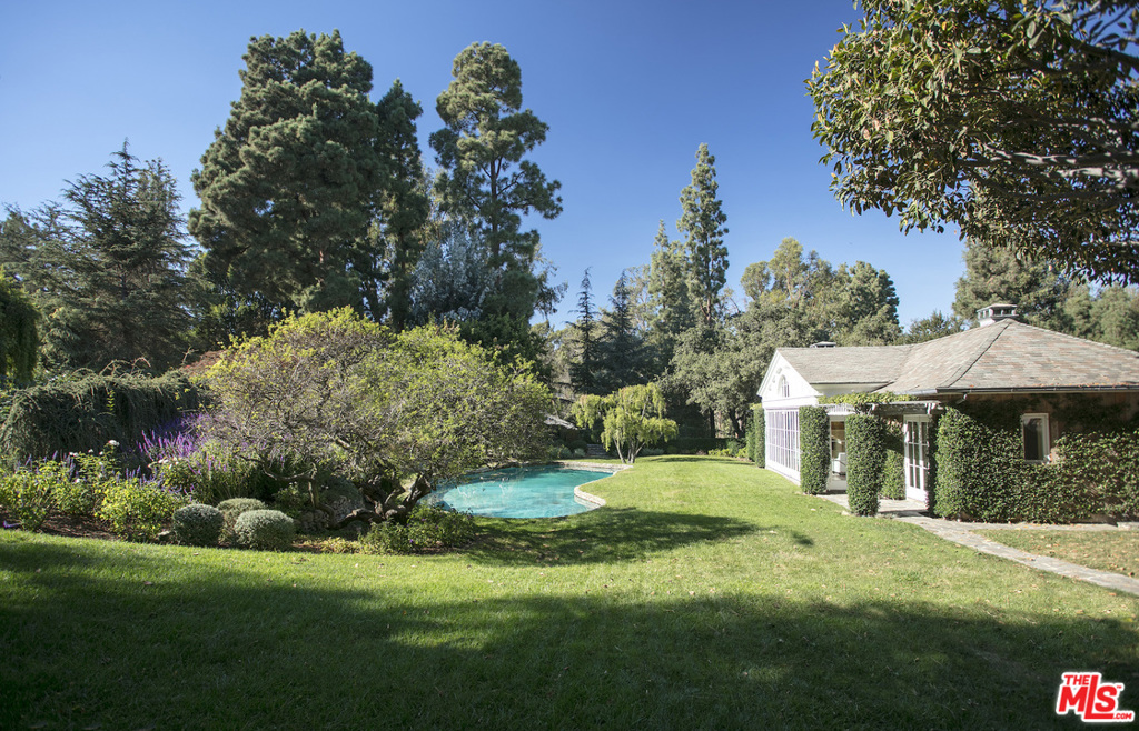 Situated in prominent Holmby Hills, this picturesque estate boasts 2.2 acres of verdant sprawling grounds with grand, mature trees, idyllic gardens, a koi pond, cobblestone pathways, peaceful fountains, a championship tennis court and a funicular. The structures on the land consist of a 2 bedroom, 3 bathroom guest house, as well as a separate two story pool house that opens to the swimming pool and outdoor lounge areas. The guest houses offer unparalleled craftsmanship that seamlessly creates a deep connection of indoor-outdoor living. The perfect opportunity to build a grand main house to complete this spectacular compound. This is a unique opportunity in one of Los Angeles's most sought after locations for a discerning individual looking to transform their dream compound into fruition.