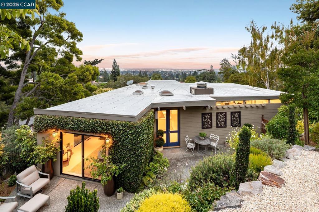 This retreat sits on the Piedmont-Oakland border, up a stone driveway and well removed from the road. Enter either through the two-car garage, or up a short stairway to the front-door in a secluded garden courtyard with a waterfall and bronze frog fountain. Enjoy the manicured garden for meals or a glass of wine in the twilight, as hummingbirds flit from one beautiful flower to another. Experience Bay views from the garden bench. The foyer sits under a skylight that invites in natural sunshine. The spacious (675 sq. ft.) living room alongside will be the center for entertainment and relaxation. It features commanding views of the Bay and Peninsula; an open fireplace to ward off winter chill; and track and recessed lighting. The nearby kitchen has cheery views to the south; it offers Miele, Sub-Zero and other top appliances and adjoins a cozy dining room. The principal bedroom suite completes the main floor. It has views on two sides and garden courtyard access, and ample closet space. Downstairs are two additional bedrooms and one fully remodeled bathroom. Each downstairs bedroom has garden views and ample closet space, and both feature extensive built-in drawers. The laundry room also is downstairs, so spacious that it accommodates both the washer and dryer and a home gym.
