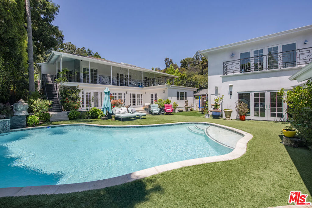 Experience the epitome of resort-style living in Beverly Hills with this extraordinary celebrity owned gated compound featuring two exceptional homes on a private corner lot. The main residence is an impressive two-story haven with six bedrooms and six bathrooms, showcasing a spacious open floor plan adorned with the finest finishes. Adjacent, the two-story guest house offers two bedrooms and two bathrooms, perfectly designed for versatility. The lower level is an entertainer's paradise with a media room, office/bedroom, and bath, while the upper level boasts a guest suite with a bedroom, bath, kitchen, expansive living room, and a large deck with breathtaking mountain views. Both homes encircle a sparkling pool with a tranquil waterfall, creating an idyllic outdoor oasis. Just minutes from the Flats and all that Beverly Hills has to offer, this property is an ideal retreat for owners, guests, extended family, or tenants.