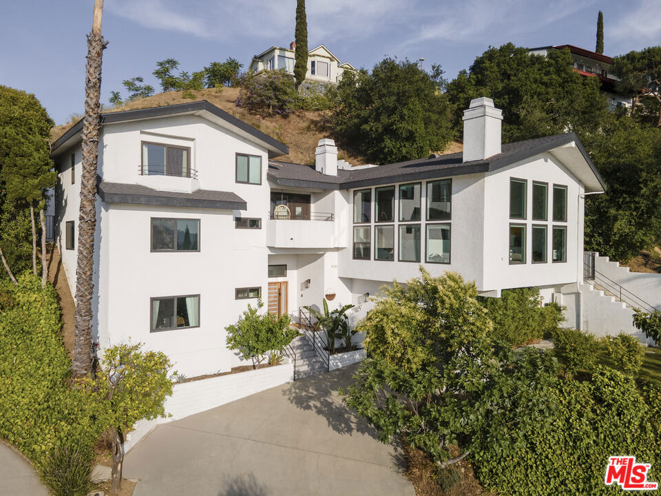 Perched in an enclave of Adams Hill, 1320 Romulus features a modernist minimal home offering unparalleled breathtaking views of mountains and city lights. This updated 4-bedroom, 4-bathroom residence spans a generous 3,102 square feet and is situated on an 8,366 square-foot lot. The seamless layout evokes a sense of grandeur and emphasizes the concept of spatial fluidity. The panoramic windows in the great room equipped with Lutron smart automated blinds allow natural sun lights to permeate every corner of the home. The sweeping unobstructed 180 degrees view serves as the perfect backdrop against the home's striking architectural clean lines and open-concept layout. A harmonious indoor and outdoor flow between the family room, kitchen and the private backyard space allows for both large-scale entertaining and relaxation, making the backyard ideal for year-round soirees. The primary suite is nested at the top of the home, offering a breathtaking sunset view. The other spacious three bedrooms are situated on the lower floor away from the primary, allowing a sense of subtle privacy. Equipped with solar panels, this home also have a high ceiling 2 cars attached garage and a 220 EV charger. Minutes from trendy neighborhood restaurants and cafe, Adams Hill is known for its rich architectural diversity, with unique homes ranging from mid-century modern to contemporary styles, each thoughtfully designed to complement the surrounding landscape.