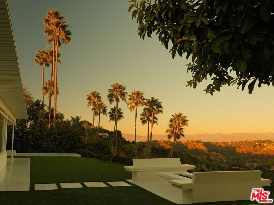 Perched in the hills of Bel Air, 2262 Stradella Road represents a striking revival of architect J.R. Davidson's mid-century vision. First completed in 1958, the residence has been reimagined through a two-year restoration that honors its original character while layering in modern materials, design elements, and smart-home technology. Expansive glass walls dissolve the boundary between indoors and outdoors, showcasing sweeping views of Stone Canyon Reservoir, the Santa Monica Mountains, and the city skyline.Inside, terrazzo floors flow seamlessly through the home, offset by custom wood cabinetry and exposed beams that emphasize its architectural pedigree. The galley-style kitchenequipped with premier appliances and handcrafted cabinetryopens to a dramatic outdoor pavilion designed for all-season entertaining. Retractable glass walls, a fully outfitted second kitchen, and built-in heating create a true extension of the home.The primary suite is secluded for privacy and framed by uninterrupted views, while the spa-inspired baths feature floating slab vanities, switch-glass privacy systems, an infrared sauna, and even a cryotherapy chamber. Outdoors, approximately 1,400 sq. ft. of living space is devoted to relaxation and entertaining, with integrated sound and media systems. A temperature-controlled reflecting pond anchors the grounds, complemented by a private putting green and fire pit perfectly oriented for jetliner views. For Sale also, and open to short term rentals. Contact for pricing and availability