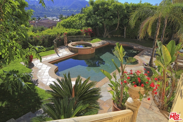 Majestic beauty and impeccable quality distinguish this palatial Bel Air Crest estate. A magnificent arched entryway with classical columns and leaded glass opens to a breathtaking central hallway with grand double staircases beneath an exquisite glass dome. Designed for luxurious entertaining, this refined residence has coffered ceilings, marble floors and the finest craftsmanship. The refined and gracious living room has an ornate fireplace. There is a spacious formal dining room, large breakfast area and gourmet kitchen. The family room has a wet bar, fireplace and balcony overlooking the pool. The master suite is a sanctuary, with fireplace, views and spa-like bathroom. There are five more en-suite bedrooms (one now a gym), plus media room, game room and elevator. The pool, spa, patio and lush garden are an oasis, with views over canyons, mountains and sunsets. May be sold furnished. A flawless estate of elegant proportions in one of Southern California's most coveted communities.