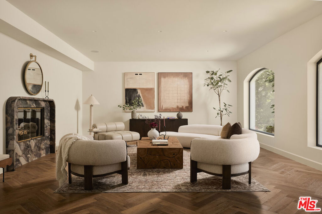 A tasteful reimagining by Louis & Rose, this residence seamlessly fuses the glamour of Hollywood Regency with the clean lines of Mid-Century design elevated by modern luxury and meticulous craftsmanship. Nestled in the Sherman Oaks hills, this 4-bedroom, 4-bathroom home on a corner lot with sweeping, unobstructed views of the hills and San Fernando Valley. The open-concept layout centers around a dramatic Great Room where living, dining, and kitchen spaces converge beneath soaring ceilings and wide picture windows. Herringbone oak floors, a custom stone fireplace, gallery-style art lighting, and a suite of Miele appliances speak to the elevated finishes throughout. A full Control4 smart home system with integrated speakers inside and out adds effortless functionality to the curated elegance. Designed for both grand entertaining and everyday intimacy, the home flows seamlessly from indoors to out. A serene central courtyard anchors the floor plan, while the backyard features an Italian stone-clad outdoor kitchen perfect for al fresco dining and gatherings. Timeless architecture meets present-day sophistication in a location that offers the best of both worlds: quiet seclusion with no through traffic, just moments from Ventura Boulevard's vibrant scene. A rare offering that balances privacy, design, and the quintessential indoor-outdoor lifestyle of Los Angeles.