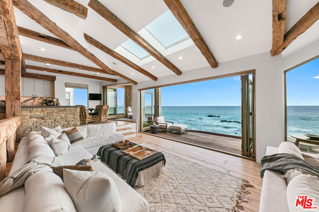 The ultimate in indoor/outdoor living and located on the best part of Malibu Road, this home has everything you need to enjoy life in Malibu. Huge glass doors disappear to reveal the stunning ocean view in front and the sandy beach below while allowing the sun to pour through and fill the space with light. A vaulted wood beamed ceiling and hardwood floors make the space warm and inviting. Beautifully furnished with multiple seating areas that can accommodate everyone whether enjoying a meal at one of two dining tables, sitting by the fireplace, watching television or just taking in the passing sea life. There's a private courtyard entrance, also with a cozy fireplace and barbecue area on the main level while the lower level brings a spacious additional ocean front living room with giant TV, bar area, hot tub, sauna, bathroom and stairs to the sand. The kitchen has all top of the line appliances, tons of counter space and is ready for a gourmet chef. Upstairs has 3 bedroom suites, including the romantic and comfortable primary with it's own private deck, sitting area, fireplace and bathroom, all ocean front. Minutes from central Malibu whether you want ride bikes to Starbucks, shop at the Country Mart, grab a bite at Lucky's or go to Nobu and SoHo House.