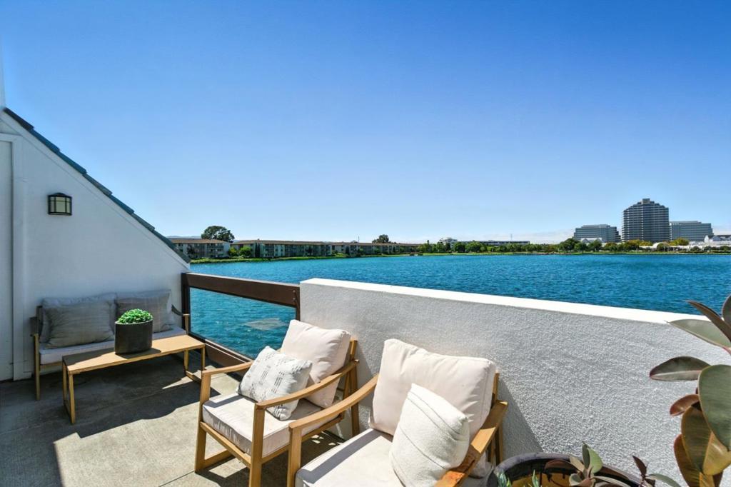 WIDE WIDE WATER VIEW! Discover unparalleled waterfront living in this magnificent home, where wide water views and an abundance of natural light define the experience. This expansive 1,490 sq ft residence boasts a spacious floor plan with high ceilings, enhancing the open and airy ambiance throughout. Featuring two generously sized bedrooms and two well-appointed bathrooms, this home offers both comfort and luxury. The large primary suite is a true retreat, complete with ample natural light and its own private balcony, perfect for enjoying serene mornings. The living room and dining area provide seamless access to a deck with stunning views of the lagoon's widest part, making it an ideal setting for watching spectacular 4th of July fireworks. Whether you are entertaining guests or relaxing after a long day, this space offers a perfect backdrop. Additional conveniences include in-unit laundry and a two-car garage, ensuring effortless daily living. Don't miss the opportunity to own this exceptional home that combines luxury, convenience, and mesmerizing views. Schedule your private tour today!