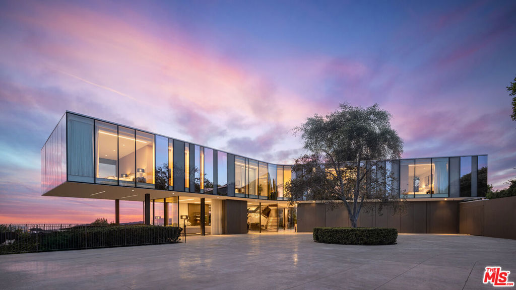 Perched atop a coveted Bel Air promontory, the Orum Residence is a striking, AIA-award winning architectural achievement that appears to float effortlessly above the city. Its sculptural three-winged form embraces 360-degree views that stretch from the Getty Center to Downtown and the Pacific beyond. Designed by iconic architect Zoltan Pali (whose work includes the Getty Villa Museum in Malibu and Wallis Annenberg Performing Arts Center in Beverly Hills,) this estate is a masterclass in contemporary design, where steel, glass, and light converge to create a home that is as breathtaking as its surroundings. Wrapped in a dynamic glass faade featuring varying opacities that shift throughout the day, the home casts reflections that blend seamlessly into the ever-changing Los Angeles sky.