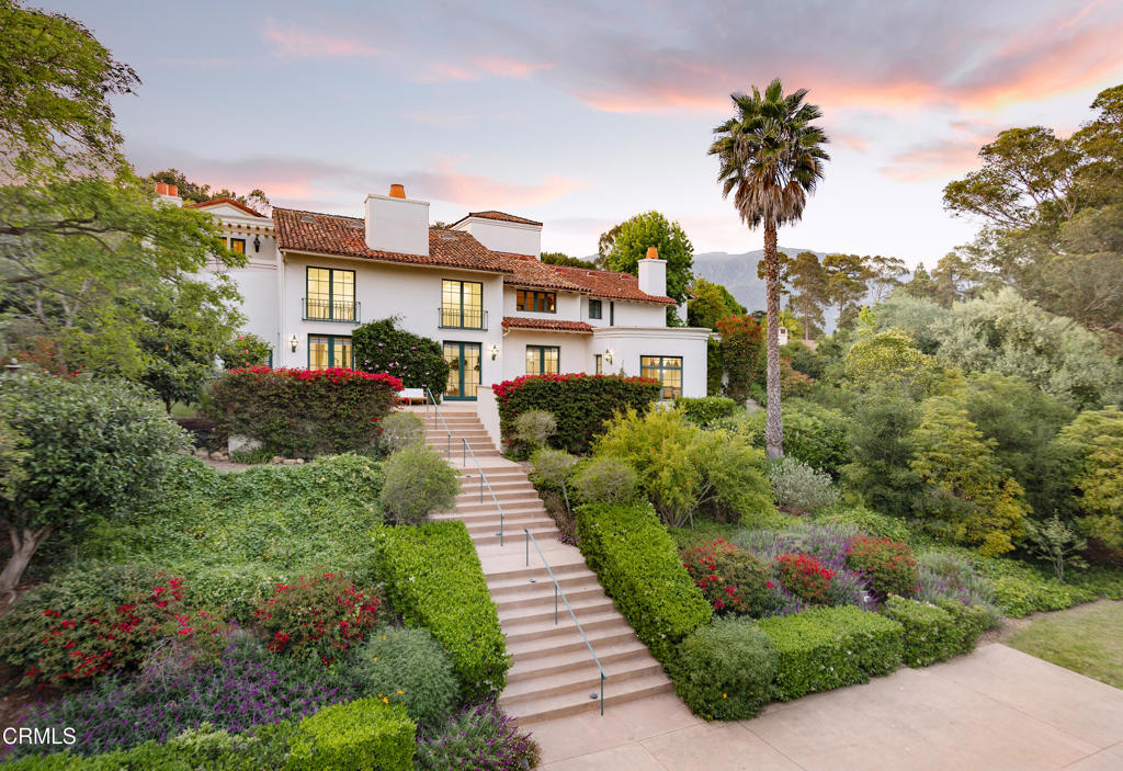 Tucked behind the gates of Montecito's coveted Ennisbrook community, 284 Gould Lane is a grand Mediterranean residence blending timeless architecture with privacy and scale. Set amid vibrant gardens on 1.68+/- acres, this expansive estate captures the romance of Santa Barbara's golden age with its classic clay tile roof and wrought iron detailing. A dramatic formal entry introduces the voluminous interiors, where a soaring great room with a stone fireplace and oversized windows offers an elegant focal point for gathering. Just beyond, the formal dining room opens to a sun-drenched terrace, ideal for indoor-outdoor entertaining. The spacious kitchen includes a charming breakfast nook and bar seating, with windows that overlook the beautiful pool and spa, creating a serene backdrop for everyday living. The bedrooms provide generous accommodations, including a primary suite with fireplace, sitting area, and peaceful views. A separate guest suite above the garage, complete with its own entrance and full bath, offers added privacy for visitors or extended stays. Multiple living spaces - including an office and cozy den with a fireplace and a flexible upstairs landing - ensure room for both relaxation and entertaining. Outside, meandering paths wind through colorful plantings, mature trees, and blooming bougainvillea. Multiple patios offer peaceful settings for al fresco dining, while the motor court and three-car garage provide ample parking and storage. Located within the highly desired Ennisbrook enclave, this residence enjoys access to community amenities including tennis courts, pool, clubhouse, scenic trails, and security. An exceptional opportunity to experience the Montecito lifestyle in a gated setting just moments from beaches, shops, and the Upper & Lower Village.