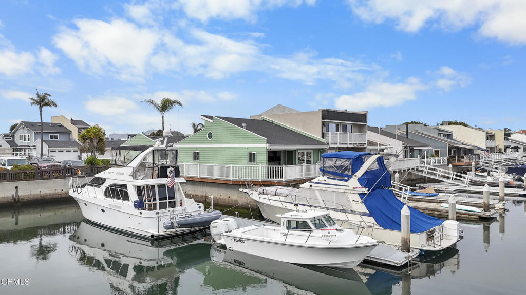 Ultimate Boater's Paradise - 100' Dock Easement & 4 Boat Docks.A rare and stunning single-level, south-facing waterfront residence in the heart of Mandalay Bay, this premium corner-lot property boasts four boat docks, one of which is shared with the neighbor to the east. Two gangways provide direct access to the water, including one completely private gangway that leads you to the full 100-foot dock easement equipped with 50-amp power and water for larger vessels. This 2-bedroom, 2-bath coastal retreat was completely renovated down to the studs in 2020-2021, blending thoughtful design with high-end upgrades. Flooded with natural light and abundant south and west sun exposure, the home feels warm and inviting from sunrise to sunset. Skylights and expanded windows enhance the open, airy layout. The kitchen features granite countertops, premium appliances, and custom cabinetry, while the expanded primary suite offers additional windows, a custom storage closet, and serene harbor views.Step outside to the wraparound west-facing deck, fully rebuilt with retrofitted supporting beams tied into the seawall. A new piling and dock were also added during the renovation, ensuring stability, longevity, and ease of use for your vessels.Additional upgrades include a newer roof, dual-pane windows, and modern systems throughout. The premium corner lot offers extra privacy, wide water views, and nearby guest parking, a rare advantage in the harbor.