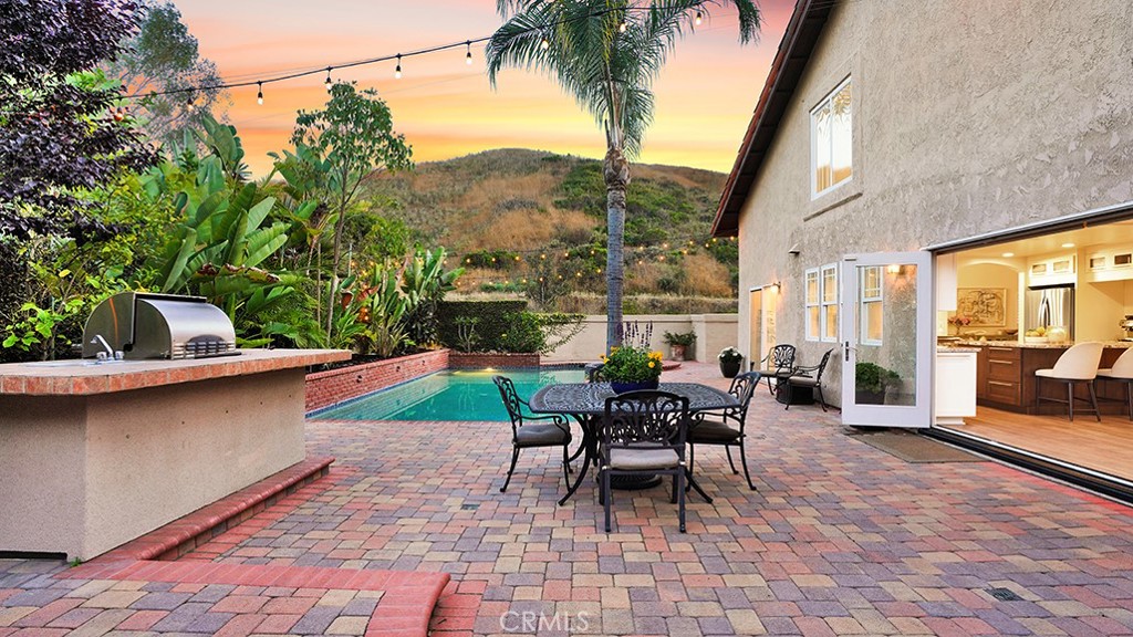 Welcome to this beautifully upgraded four-bedroom, three-bath home nestled on a spacious 10,032 sq ft lot in the coveted Los Corrales community of San Juan Capistrano. With gorgeous views of the surrounding hills and horse trails, this home offers the perfect blend of tranquility, functionality, and SoCal lifestyle. Inside, you’ll find two spacious living rooms, vaulted ceilings, and an open-concept layout that flows effortlessly throughout. The remodeled kitchen is a chef’s dream, featuring a large center island, farmhouse sink overlooking the backyard, custom cabinetry, and a six-burner range with hood. The adjacent family room is warmed by a cozy fireplace and opens to the backyard through a stunning wall of bi-fold doors, inviting indoor-outdoor living. Downstairs includes a formal living and dining area with a fireplace, beautiful stained glass window, a guest bedroom with full bath and walk-in closet, and a dedicated laundry room. Upstairs, the primary suite is a true retreat with vaulted ceilings, a two-way electric fireplace, a remodeled en-suite bath with double vanities, soaking tub, skylight, and separate shower. Step out onto the oversized balcony to take in breathtaking views. The two additional upstairs bedrooms are generously sized, each offering a gorgeous view of the backyard and pool. Upstairs hall bathroom has double vanity. Enjoy year-round entertaining in the expansive backyard, complete with a sparkling pool and spa, stand-alone sauna, grassy area, multiple seating zones, and built-in BBQ. Mature fruit trees—including orange, grapefruit, lemon, and pomegranate—add a lush, vibrant touch. Ideally located near San Juan’s charming Historic Downtown, local beaches, equestrian and hiking trails, and Dana Point Harbor—this is the home that truly has it all.