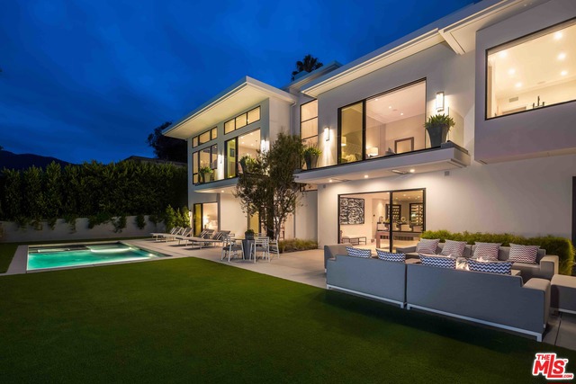 Minutes from the beach in the seaside neighborhood of Castellamare, Pacific Palisades-often compared to the Amalfi Coast in Italy-this stunning contemporary compound boasts sweeping ocean, mountain, and canyon views. Interiors are enhanced by soaring ceilings, white oak floors, walls of glass, and natural light, with the design taking full advantage of available views. An open-plan living room features a balcony and whitewater views of the Pacific, with a formal dining room and chef's kitchen. Two generous guest rooms and a large master with gorgeous bathroom, showroom closet, fireplace, and balcony are at the main level. An expansive lower level features an open living area, wine room, fully-equipped bar, theater room, and three guest rooms. A sprawling backyard features a fire pit and lounge area, waterless grass, and a pool and spa. Additional finishes include LED lighting, a Control4 Smart Home system, skylights, two laundry rooms, and drought-tolerant landscaping.