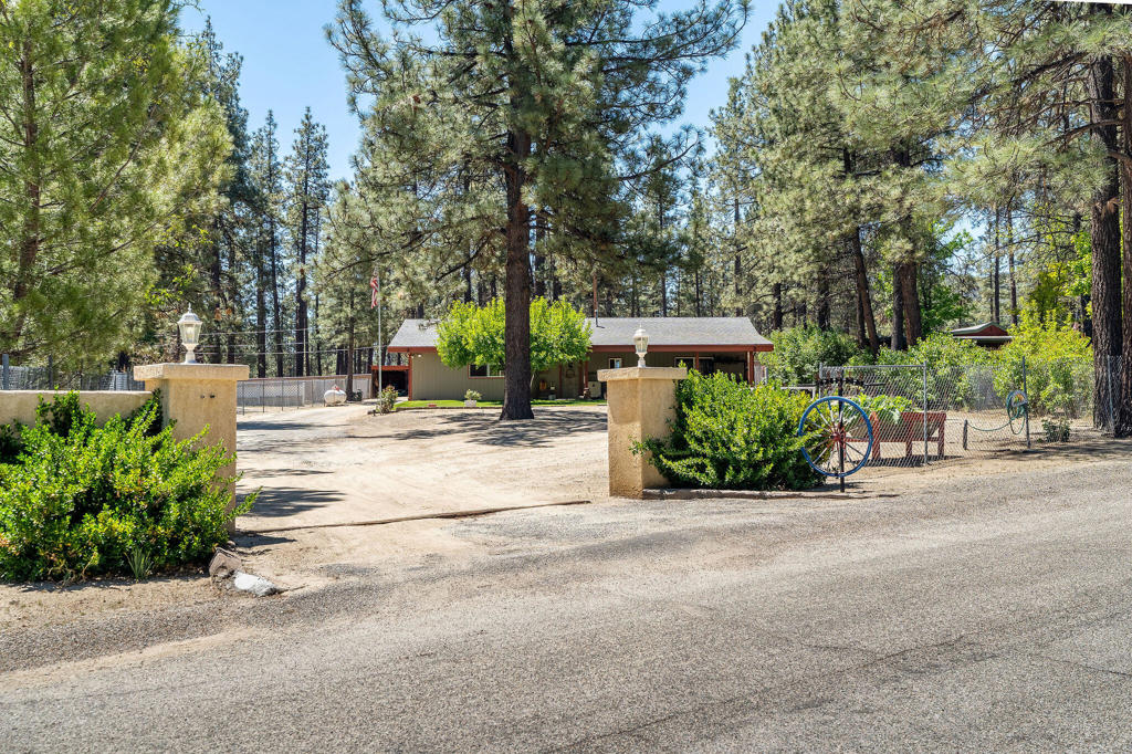 Escape to peaceful mountain living with this well-maintained, move-in-ready home nestled on a spacious .38-acre lot. Perfectly blending comfort and functionality, this property offers the ideal balance of outdoor space, storage, and cozy charm. Enjoy your morning coffee on the covered front porch, or unwind in the evening on the covered back patio while taking in the fresh mountain air. A wood-burning fireplace adds warmth and character to the living space, while ceiling fans throughout the home help maintain year-round comfort. For those needing room to work or store gear, the property includes a 20x30 metal shop, a large storage shed, and ample space for hobbies or outdoor projects. Fruit lovers will appreciate the mature apple tree in the yard-perfect for fresh snacks or homemade pies.Whether you're looking for a weekend retreat or a full-time residence, this home is move-in ready and full of potential.