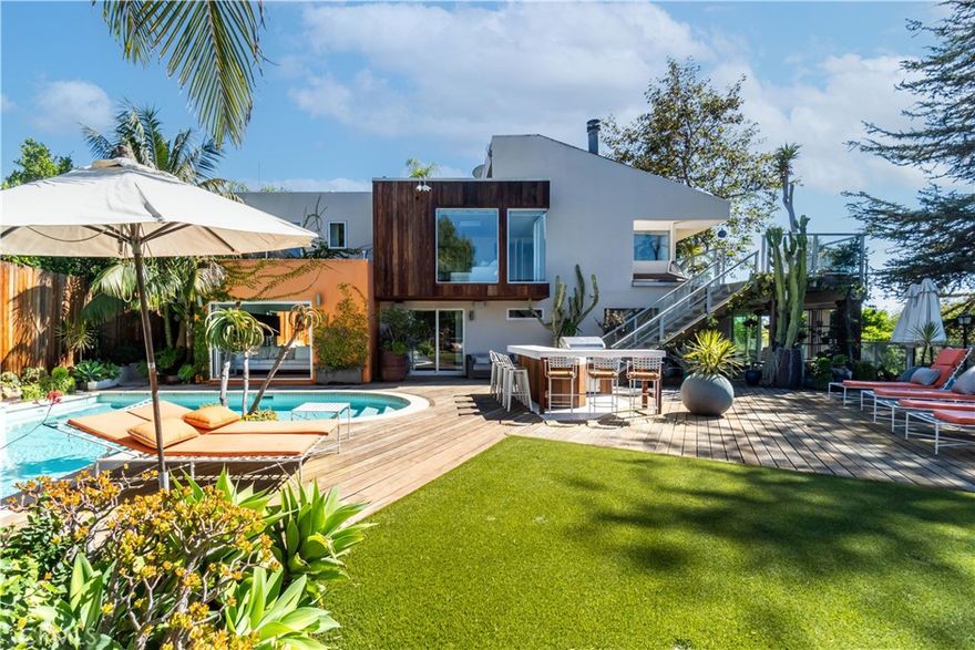 Secluded down a 100-foot driveway, this gated estate offers expansive ocean and canyon views with unmatched privacy. The main level features three bedrooms, including a stunning primary suite that opens to resort-style grounds with pool, spa, cabana, outdoor kitchen, fire-pit, and lawn. Upstairs, an open living and dining area flows into a gourmet kitchen with designer appliances, plus a guest suite with separate entrance and a den/office. Sliding glass doors lead to a large deck with al fresco dining, fireplace, and lounge seating—perfect for enjoying sunset views.