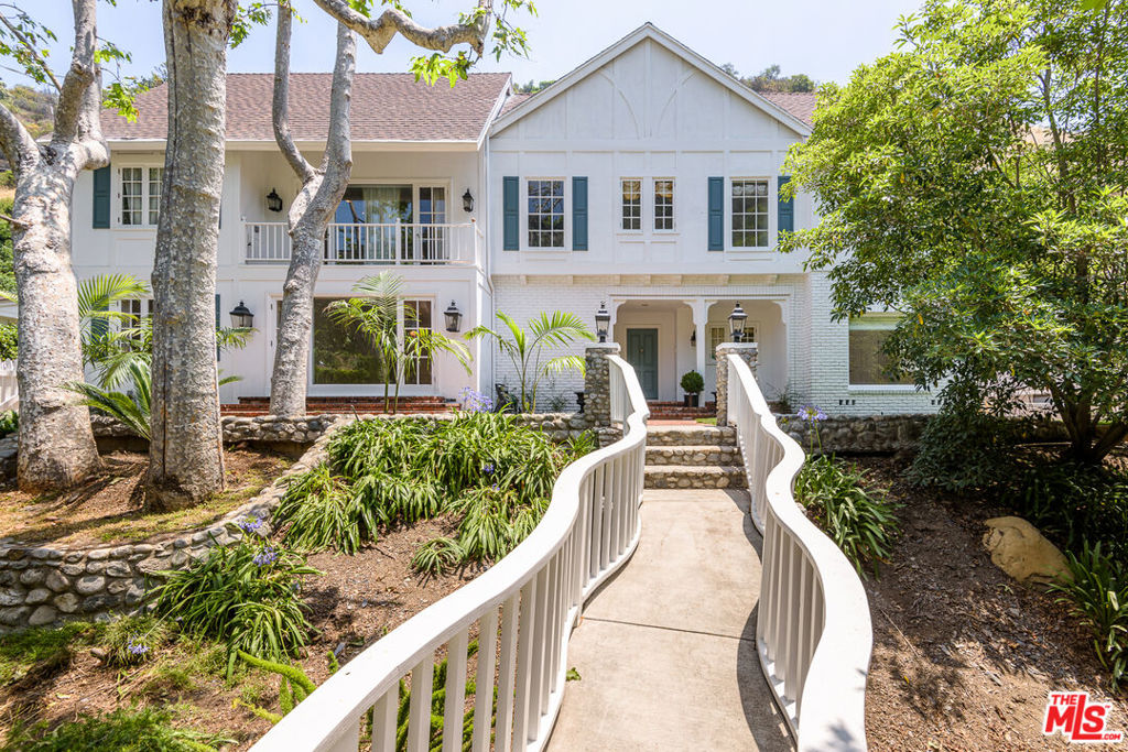 Very private Country English with 5bd, 4.5 bath plus a detached guest room above the 3-car garage. Tucked behind a tall privacy hedge & across a bridge over the creek bed. Tons of character & charm! Just 5 pleasant minutes up Mandeville! Hardwood floors, built-ins, brick patios, hillside & treetop views! Huge living room with built-in bookshelves & fireplace open to sunny backyard with water feature. Oversized formal dining room with picture window. 5th bedroom suite/den with wet bar & fireplace. Kitchen features stone counters, stainless Viking appliances and indoor brick BBQ grill! 3 bedrooms downstairs & 2 upstairs. Dual master suites, each featuring lovely treetop views, large walk-in closets, fireplaces & luxurious baths with soaking tubs, sauna & steam shower. Private backyard with rock waterfall & hillside privacy. 3-car garage with a guest room above featuring a kitchenette (stove, sink & mini fridge) plus full bath & private deck. A peaceful retreat!
