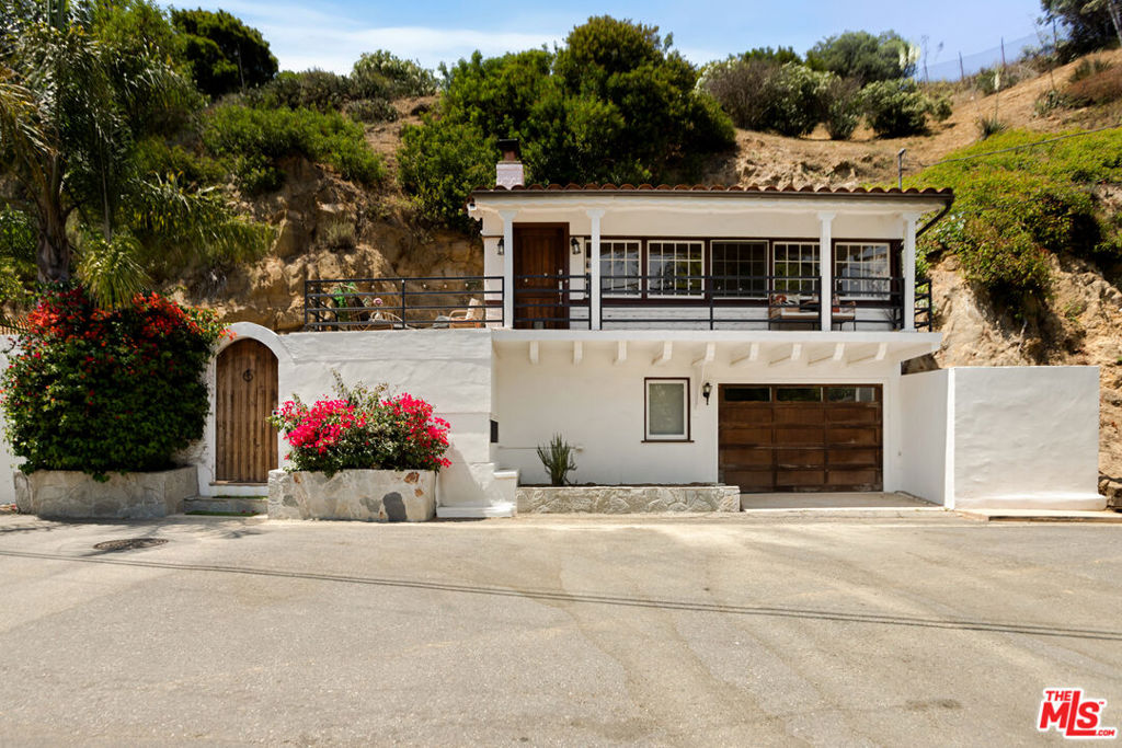 Set above the city in the desirable Hollywood Manor neighborhood, this updated Spanish style hideaway offers charm, privacy, and everyday ease with easy access to studios, hiking trails, and beloved Valley and Hollywood hot spots. A peaceful courtyard welcomes you with a calming fountain and a sense of retreat from the bustle below. Inside, warm wood floors and natural light create an inviting atmosphere. The main living space features dramatic wood-beamed ceilings, a stone fireplace, and a wall of windows framing beautiful hillside views. The kitchen balances form and function with stone countertops, custom cabinetry, and a breakfast bar that opens to the living and dining areas, ideal for casual meals or hosting. Just off the main level, a generous terrace invites al fresco dining or morning coffee in the sun. Downstairs, a versatile bedroom suite with private entrance and bath offers flexibility for rest, work-from-home, or creative use. Tucked into a quiet canyon, this home is minutes from Universal Studios, the Hollywood Bowl, the 101 Freeway, and the shops and restaurants of Studio City and Hollywood. A rare blend of character, comfort, and convenience. Come and see what pure peace looks like!
