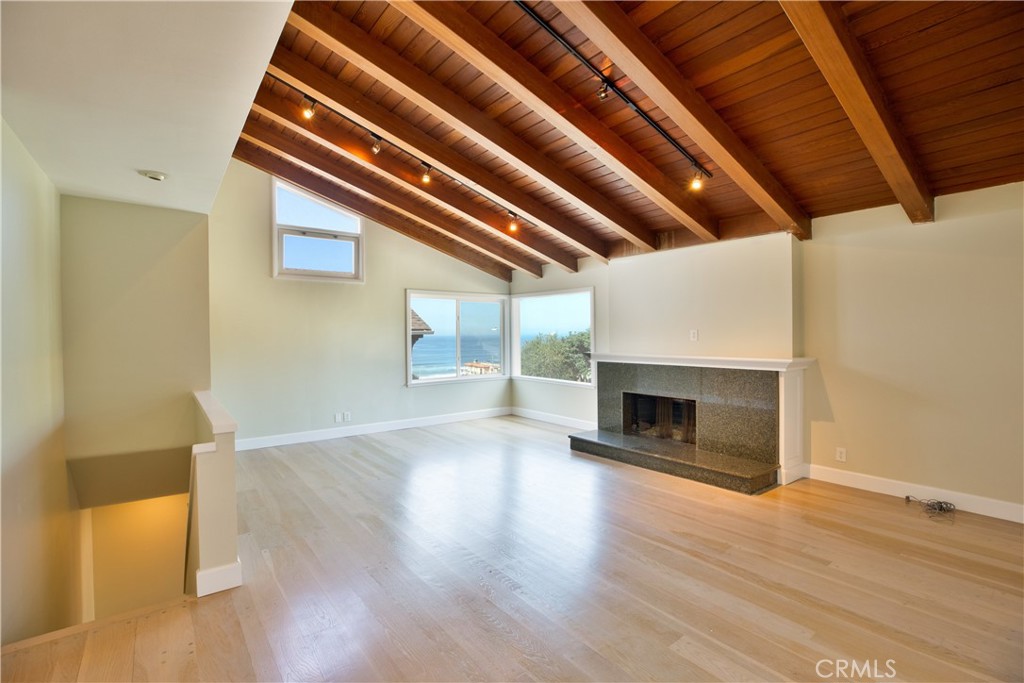 Tucked into the sought-after Sand Section of Manhattan Beach, this charming coastal home captures views of the ocean, coastline, and Bruce’s Beach Park. Just a few blocks from the sand and the Strand, the home blends classic beach charm with everyday comfort, offering a front-row seat to the best of coastal living and all the South Bay has to offer. Inside, sunlight pours into the main living room, where vaulted ceilings, a fireplace, and expansive windows showcase unforgettable sunsets. The flexible layout features a living room upstairs, three bedrooms plus an office/nursery, a den/family room on bottom level, and two fireplaces, all set against the warmth of wood flooring. Out back, a private yard is designed for easy entertaining, with a wood deck and café lights creating a relaxed, coastal ambiance. The home also offers practical conveniences, including a two-car garage with alley access, a wine cellar with additional storage, and laundry on the lower level. Located within moments of Grandview Elementary, neighborhood cafés, and local dining favorites—with public parking nearby—this residence places Manhattan Beach’s coveted lifestyle right at your doorstep.