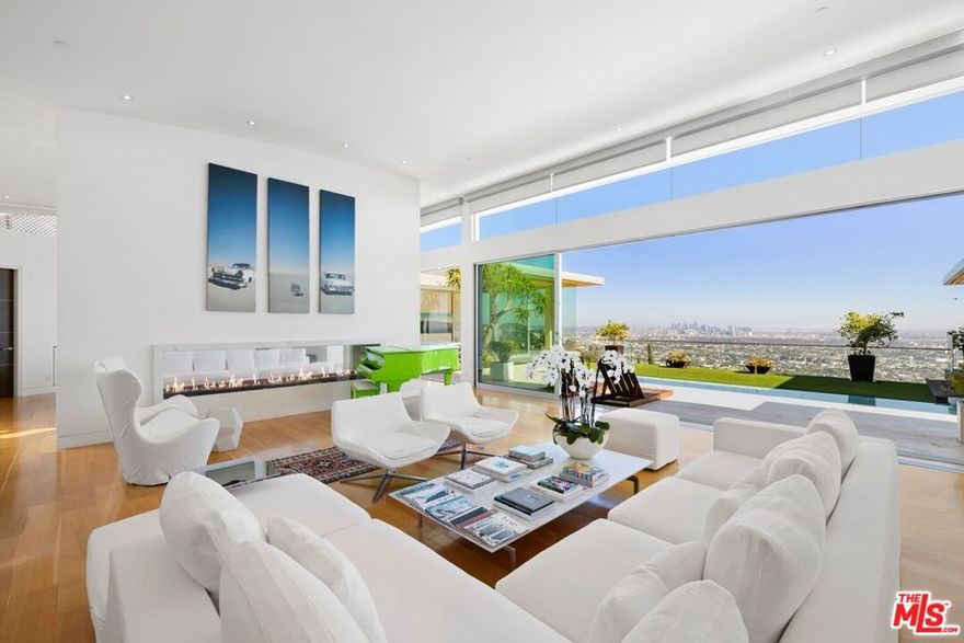 This sleek Paul McClean-designed contemporary home is located on the coveted eastern side of Blue Jay Way, offering one of the most desirable perspectives in prime Hollywood Hills' Bird Streets. The home's open-concept design features soaring ceilings and disappearing Fleetwood doors that create a seamless flow for indoor-outdoor living. The open-concept gourmet kitchen is equipped with top-of-the-line Miele appliances, a large island, and bar top seating. Fall asleep to city lights and wake to the sunrise in the glass-wrapped primary suite, featuring dual bathrooms and closets. Outside, you'll find a newly refinished pool with chaise lounges and an outdoor cabana, complete with a built-in BBQ, fireplace, and heaters. Available fully furnished for month-to-month or long-term leasing. Additional photography is available upon request.