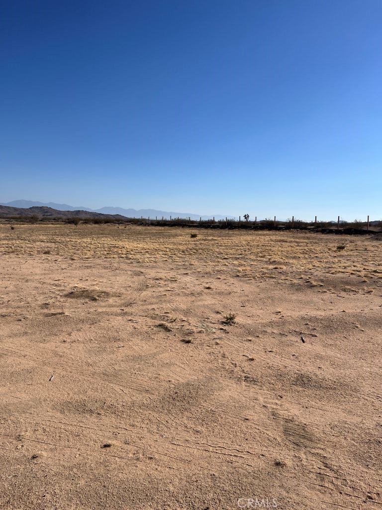 2.5 Acres of land for sale in Adelanto, California surrounded by beautiful desert landscape with mountain views in the distance. A neighbor in the area has installed a Modular/Prefabricated Home and others have Motor Homes on their property. Dirt road access.