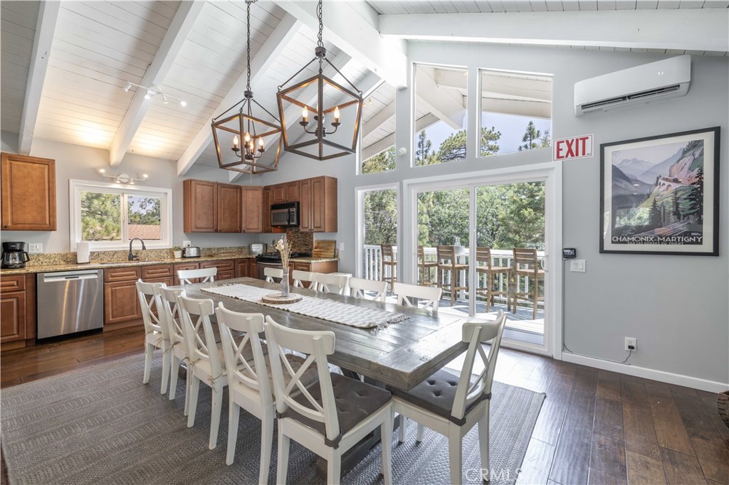 This bright and airy Moonridge home is perched above Big Bear in a quiet, well-treed neighborhood. The tasteful decor and neutral color palette provide a serene air of tranquility to this mountain getaway. The main floor of this reverse floorplan home is wide-open, with vaulted ceilings, dark wood floors, stone fireplace, mini-split air conditioner, fully-appointed kitchen, and lots of space for dining and entertaining and taking in the views from the two decks off each side of the home at this level. Downstairs, three cozy bedrooms, two full baths, heated laminate floors, and access to the large first floor deck with sunken spa provide easy access to comfort, outdoor dining, and social spaces. This home has been operated as a vacation rental, and is outfitted for groups and families, but would also make a great full-time residence or part-time home. This property is located near the Bear Mountain side of the resort, and just a short drive to dining, activities, events, as well as the Lake and Village.