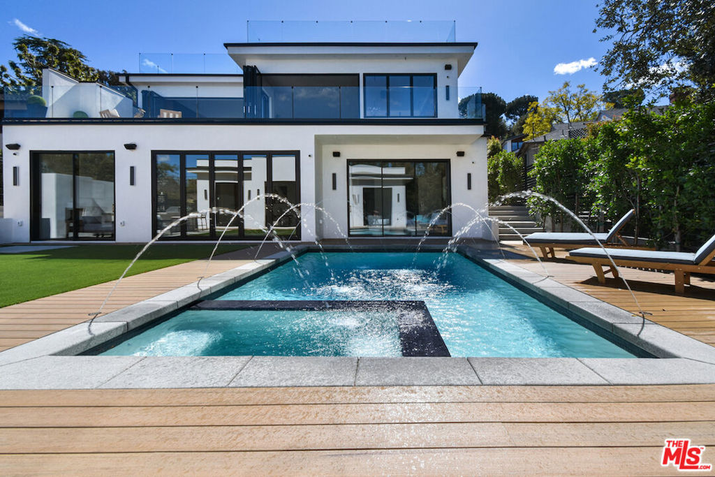 The epitome of luxury, this brand-new 2025 construction is a stunning 6-bedroom, 5.5-bath residence spanning 6,400 square feet and perfectly situated south of Ventura Boulevard in the heart of Studio City. Offering both serene privacy and unmatched access to fine dining, entertainment, major Hollywood studios, and the vibrant Sportsman's Landing, this exceptional home is also located near top-rated schools and offers easy routes to Downtown LA and Beverly Hills. Crafted by a seasoned professional builder, the home features exquisite details such as white oak hardwood floors, rich walnut paneling, and striking designer lighting. Expansive 10-foot floor-to-ceiling bi-fold glass doors seamlessly connect the open-concept interior to the outdoors, capturing the essence of California living. The gourmet kitchen is a chef's paradise with an 8-burner Wolf range, high-end appliances, a show-stopping island, and Taj Mahal Calcutta marble surfaces, complemented by a secondary chef's kitchen for effortless entertainment. Step outside to a 680-square-foot patio perfect for alfresco dining or ascend to the rooftop deck complete with 360-degree views, a bar, outdoor kitchen, fire pits, and sleek glass railings. The lower-level retreat offers spacious bedrooms and a cozy family room that opens to a lush backyard with a pool, built-in BBQ/kitchen, and a detached guest house featuring soaring ceilings, a full kitchen, and two additional bedrooms ideal for guests, extended family, or a private office. Equipped with a state-of-the-art smart i-Port home system and 14 security cameras, this home is a rare fusion of cutting-edge technology, refined design, and enduring comfort.