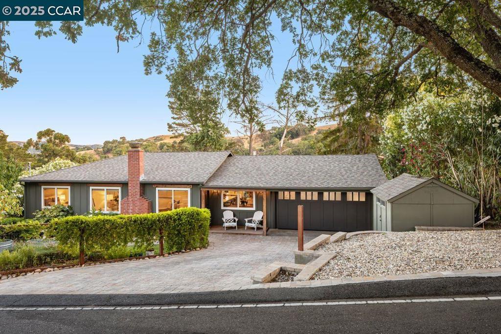 Welcome to this inviting Lafayette home, perfectly situated between the sought-after Burton Valley and Silver Springs neighborhoods. A stately redwood and mature white oak greet you at the entrance, setting the tone for the tranquil living experience that awaits. Step inside to a spacious living room—nearly 300 square feet—anchored by a striking wood-burning fireplace with a classic brick surround. Just off the living room, the updated kitchen shines under recessed lighting, featuring sleek quartz countertops, an island for casual dining, and nearly new appliances. The kitchen flows seamlessly into a cozy dining area with custom cabinetry and an adjacent wet bar complete with a wine fridge—ideal for entertaining. Down the hall, you’ll find three comfortable bedrooms. Step outside from the kitchen onto a sun-drenched deck—perfect for outdoor dining, grilling, or simply relaxing, while enjoying serene views of the wooded hillside across the valley. Need a space to work or create? An attached office/studio with its own entrance provides a peaceful, private setting for productivity or inspiration. With easy access to St. Mary’s Road, you're minutes from Burton Valley Elementary to the south and Stanley Middle School to the north—making this home as convenient as it is charming.