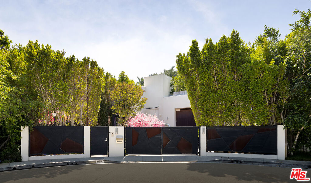 Introducing LUMINOSITY, an eclectic celebration of color and light, a vivid sanctuary of artistic splendor, an exotic play-place for all ages. Concealed behind gates and privacy hedges, this bedazzling compound promises pops of color everywhere, beginning with a dramatic stone pathway set beneath geometric arches and flanked by dual fire pits atop a reflecting pool with cherry blossom feature. Party guests arrive into a striking 25-foot foyer adorned in 32 slabs of open-book panda white marble, illuminated by seven chandeliers. Shape, angle, and pattern converge in the formal living room with its living moss walls, reimagined decorative fireplace, iridescent light displays, and piano nook. Numerous floor-to-ceiling and double-height book and display cases can be found throughout, drawing the eye upward and enhancing vertical volume. The kitchen is centered by a Brazilian marble waterfall island with backlit Patagonia and onyx marble serving ledge, gorgeous gothic chandeliers, and state-of-the-art brands such as Wolf and Miele, including three ovens, custom refrigerator, and cooktop. This creative culinary space also opens to an enchanting entertainer's deck with barbecue, perfect for evening drinks and dining al-fresco. Other public spaces inspire imagination with unique, thought-provoking fixtures and psychedelic finishes. The primary suite is spacious, with a sitting area and fireplace, fantastic Japanese soaking tub enclosure with lit onyx wall, and oversize changing wardrobe. For endless entertainment possibilities, there is a ball pit with projection screen, billiard/foosball room, and state-of-the-art cinema room with loft seating. There is also a gym and two laundry rooms. Smart home automation is by Lutron and controlled by iOS, Sonos speakers are found throughout, and EV charging is enabled in the garage. Outside, discover a pool and spa with baja shelf and Bellagio water feature, inspiring murals, side patios, terraces, and outdoor kitchen and bar surrounded by a mote. For the more rambunctious, there is a mini play park complete with swing apparatus and jungle gym. Furniture is included in the sale. This private wonderland promises a lifestyle of ultimate leisure and never-ending discovery. Welcome!