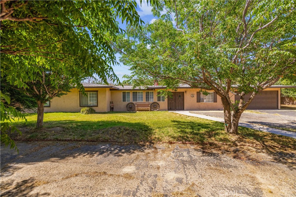 A Rare Gem in the Heart of Littlerock. 2 homes on 1 lot. Where Rustic Charm Meets Endless Possibilities! Welcome to your own private oasis! This extraordinary estate offers over 3,000 sq ft of living space, featuring 6 bedrooms (with 2 master bedrooms), 4 bathrooms, and nearly a full acre of land—perfectly combining comfort, charm, and opportunity. Step through the stucco privacy walls into a timeless hacienda-style retreat that immediately transports you. The thoughtfully designed floorplan boasts expansive living areas, ideal for entertaining and multi-generational living. From the cozy living room to the elegant formal dining space and oversized family room, every corner flows seamlessly into the large, inviting kitchen. A hand-crafted fireplace anchors the space with warmth and authentic character. Outside, the magic continues. Enjoy multiple patio areas, hammocks under shady trees, and a dedicated outdoor dining space designed for relaxation and entertaining under the stars. The lush grounds are adorned with a variety of fruit and shade trees, bringing nature's bounty right to your doorstep. Perfect for hobbyists, entrepreneurs, or animal lovers, this property features a massive 5-bay workshop (currently serving as a carport), multiple storage sheds, animal enclosures. Additional highlights include: Public water and natural gas for convenience. The detached guest house offers its own private living space with 1 bedroom, 1 bathroom, a living room, dining area, and full kitchen, ideal for extended family, guests, or potential rental income. Peaceful, private setting with room to breathe and grow. This isn't just a home it's a lifestyle. Don't miss your chance to own a one-of-a-kind property that truly has it all.