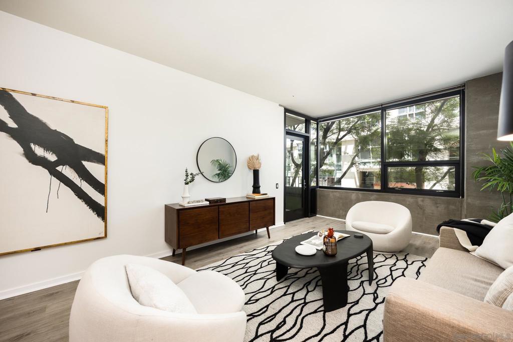 Welcome to ICON, where industrial style meets modern comfort in the heart of East Village. This thoughtfully updated unit features an open-concept layout with soaring ceilings and striking concrete accents. Alongside the spacious primary bedroom, you will find a versatile flex space that is ideal for a home office or creative studio. Enjoy the convenience of in-unit laundry, secured underground parking, and access to ICON’s impressive amenities. These include a state-of-the-art fitness center, private movie theater, resident lounge, 24-hour security, and concierge service. Best of all, the iconic 26th-floor Skybox rooftop deck offers panoramic views of The Bay, Coronado Bridge, and Petco Park, where you can watch Padres games and concerts for free. Just steps from coffee shops, dining, and nightlife, this is urban living at its finest.