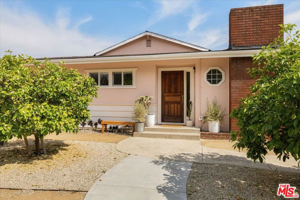On a cul-de-sac in the heart of Atwater Village you'll find this stylish remodeled residence, gated and set back on an impressive flat lot. The light-filled living room with a brick fireplace welcomes you, making one instantly feel at home. A spacious dining area leads into the tastefully modernized kitchen with a touch of whimsy and boasts a custom eating nook and direct access to a covered patio for your al fresco dining. A laundry room with access to the semi-finished attic will delight as you imagine all the possibilities. The office/den area anchors the three well-appointed bedrooms, including the gorgeous primary suite with a spa-like bathroom and custom walk-in closet. Step outdoors to a serene covered sitting area and find beyond the privacy fence an expansive flat grassy area providing plenty of room for a pool, ADU, or SB9 opportunities. The oversized garage plus a separate bonus room is the perfect setting for a future development, creative studio, or extra storage. Amenities include beautiful hardwood floors, central heat and air, and a drought tolerant front yard w/ grapefruit trees. Rarely found is a property that's completely ready for you to move in while setting a stage for future expansion, additions and endless possibilities.