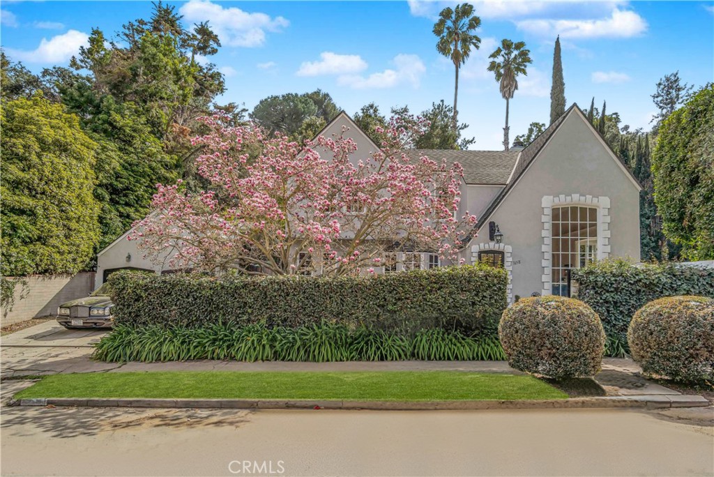 Pass through the gate and step into your private walled sanctuary. Romantic French Normandy style corner lot home with saltwater swimming pool, an architectural gem built in the roaring 1920’s; prominent palladium window, tall ceilings and a gable roof, reminiscent of homes found in the European countryside. The magnificent living room features 10’ ceilings, large windows, and French doors that open to a pool area surrounded by ivy clad walls and mature hedges ensuring privacy. The kitchen features dark wood cabinets, marble countertops, mosaic tile backsplash, Viking stove, Subzero refrigerator, ASKO SS dishwasher and an adjacent pantry room w/ laundry. Solid hardwood walnut floors are present throughout this home. Host a dinner party in the large dining room overlooking a beautiful Lily Magnolia tree, or step through French doors to the TV room that could also double as a 4th bedroom. Bedroom #3 has built-in bookcases, lead-glass windows and an adjacent, elegant ¾ bath finished in Carrera marble. Upstairs, a long hallway offers gallery-style wall space leading to two bedrooms with serene views & ample closet space. The beautifully updated bathroom at the end of the hall maintains classic character with period fixtures, a new vanity plus a deep soaking tub.
Oh, the backyard! Lush & private, an abundance of flowers and greenery surrounds the decking, BBQ area, saltwater pool w/ waterfall and Pentair ScreenLogic controls. A tranquil place to relax or entertain. The two-car gated driveway leads to the garage which has been finished with built-in cabinets and is currently used as an artist's studio: the upstairs offers a non-permitted mother-in-law suite. Meticulously maintained; upgrades include a NEW 5 ton HVAC system, bolted and upgraded foundation, copper plumbing and a 200-amp electric panel. Additional improvements include Wi-Fi controlled lighting, Leviton Maestro dimmer switches, tankless water heater, illuminated crawl space & an outdoor gardening station. This Hollywood Hills neighborhood features underground utilities, sidewalks, and classic architecture. A 20-minute walk to Runyon Canyon’s Mullholland gate and less than a mile from Valley View Elementary School. You’ll appreciate being able to walk to Universal Studios and be downtown in under 30 minutes.