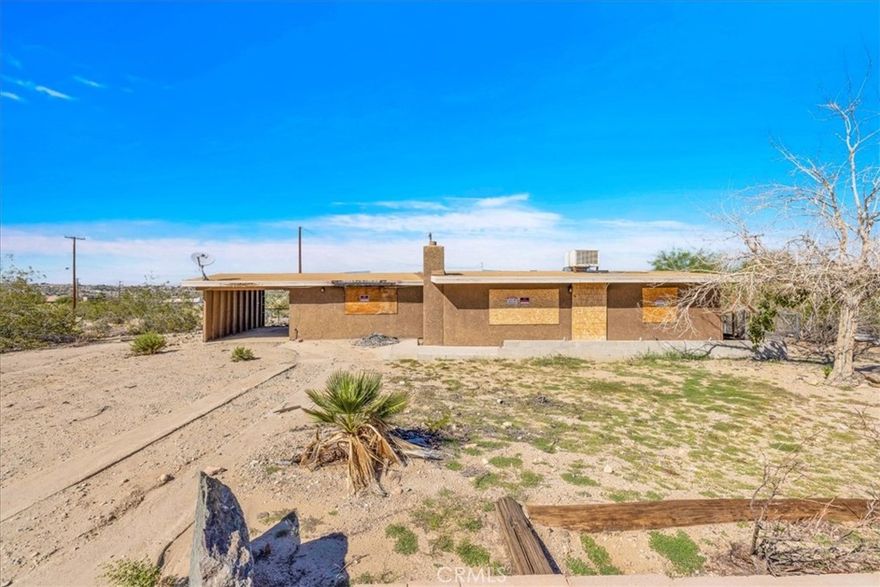 Investor special or renovation opportunity in the desirable Hanson area of 29 Palms! This 2 bedroom, 1 bath home sits on just over a quarter acre and offers excellent potential for someone ready to restore and reimagine it. The property experienced a fire and is currently boarded up, but it’s easy to see the promise in its solid bones and spacious layout. The home features a large living room with beamed ceilings and expansive windows that once filled the space with natural light. The kitchen area offers plenty of room for redesign and includes French doors that open to the outdoors. Both bedrooms are nicely sized with built-in storage in the closets, offering a strong starting point for a modern refresh. Outside, the property includes an attached carport and a storage shed, with room to create a comfortable outdoor living space. Located just minutes from the entrance to Joshua Tree National Park and close to local amenities, this property is a true diamond in the rough—ready for the right buyer to bring it back to life and make it shine.