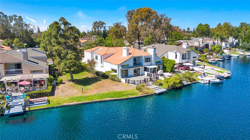 Welcome to the exclusive community of Hidden Lakes. Tired of the same old tract home? This remodeled lakefront, corner lot home is open, spacious and offers incredible views for the new owner. Features include a completely remodeled kitchen & dining room that overlooks the backyard, dock, and beautiful Lower Lake. The Living Room offers cathedral ceilings and lets tons of natural light into the home, plus sweeping lake view. Upstairs, The master bedroom is huge and also offers panoramic water views. Wake up to paradise every day! There are also 3 more spacious bedrooms upstairs. However, the best feature is the large backyard that wraps around the home and ends with a private dock. Entertain all summer in your yard or cruise the lake on your boat. Like to fish or paddleboard? This is the home for you. The beautiful mix of lake, grassy shoreline & eucalyptus trees gives you an environment unlike any in Orange County. Plus, you’re not only buying a great home, but buying into an active community with loads of activities & social events HOA dues include access to the Lake Forest Beach and Tennis Club, a mere 5 minute walk away. There you will find 3 pools, a swimming lagoon, pickleball, tennis, basketball, volleyball, myriad social clubs & events, and amazing lake views as well. Stepping into this home will leave you with a sense of peace and calm, so check it out today!