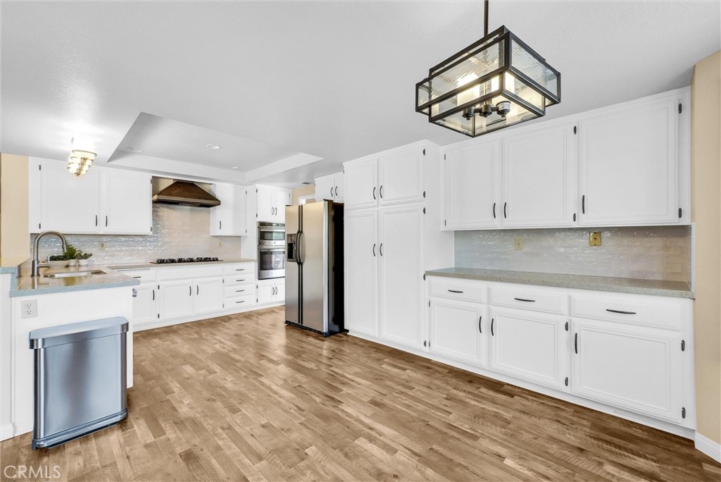 VA ASSUMABLE LOAN at 2.750% - these opportunities do not come up often! This gorgeously remodeled pool home in the prestigious Lake Hills neighborhood sits at the end of a cul-de-sac and has paid off solar complete with 40 panels! This one of a kind property boasts 2,840 sq ft of living space with 4 bedrooms plus an oversized loft and 3 full bathrooms. Entering the home you are greeted into the main living room that opens to the dining room where you have a large slider leading off to the back patio. As you pass through to the separate family den it flows right into the fully remodeled kitchen with refinished cabinetry and Quartz counter tops that are accented by a beautiful subway tile backsplash. The kitchen is fully equipped with a new double oven and sink with faucet. Downstairs you have one bedroom and a tastefully remodeled bathroom and also your laundry room with a door leading to your backyard. Upstairs your oversized primary bedroom has soaring vaulted ceilings and two separate closet spaces for ample storage needs. There are an additional 3 bedrooms upstairs and a large loft that has a large set of built in shelves and desk currently set up as an office and could easily be converted into a 5th bedroom. The backyard on this home is the perfect setting for entertaining or relaxing in the pool as your backyard is nestled up against a serene lush strip of trees and shrubs providing ample privacy. Garage is also set up with car charging capabilities. Your dream home has finally arrived!