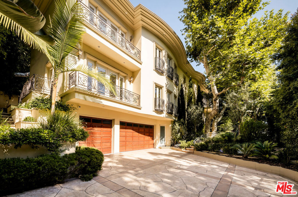 Positioned behind privacy gates amidst lush, verdant landscaping is this extensively remodeled Tuscan offering numerous amenities and updates throughout. Enter the motor court to experience beautifully designed and manicured gardens adorning the path to the home's elegant, towering double-door entry. Inside, a lofty double-height foyer is accented by an ornate chandelier and grand circular staircase. The formal living room features French doors and opens to the family room, perfect for entertaining. The updated kitchen is equipped with a large center island with prep sink, ample cabinetry, and state-of-the-art appliances including a Wolf range, Sub-Zero refrigerator, and Miele warming drawers, espresso machine, and dishwasher. A series of French doors in the formal dining room open to Juliet balconies to create a breezy al-fresco feel. The primary suite is expansive, with sitting area, private balcony, fireplace, dual voluminous walk-in closets with built-ins, and sumptuous spa-inspired bath. Secondary bedrooms are also beautiful and well-appointed, some also with private balconies. Other important features include a pajama room, office, wine cellar, theatre, and large lower-level lounge ideal for billiards, piano, and more. With wellness top of mind, there is also a massage room, sauna, and steam shower. The paradisal backyard is reminiscent of summers spent on holiday with a resort-like cabana/outdoor living room, adjacent built-in barbecue, shimmering pool with European lion head water spouts, spa with waterfall, ample lounging patios, and terraced garden. There is also a soothing fountain in the front yard, rounding out this wonderfully peaceful paradise. With its enchanting, secluded feel and close proximity to the city, there is no surprise that so many celebrities choose to call Benedict Canyon home. Welcome! This Four Seasons-inspired home is also available for lease at $45,000/month.