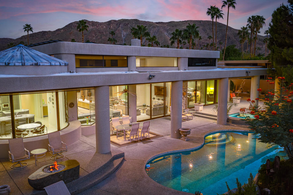 One of the ONLY true architectural, custom homes in Indian Canyons. A step above the rest. There are grand proportions throughout this 3,687 sq ft 4 bedroom/5 bath home. The view and orientation are perfect. With a fabulous pedigree, designed by Holden & Johnson Architects and built by Stoker Construction in 1993. Plate glass and steel reinforcements were used throughout to create expanses which soar across large open volumes with exceptional, uninterrupted views. Other custom design features include textured wall treatments, tongue and groove ceilings with unique details, monumental solid slab fireplace, and a dramatic wet bar which delivers front row seats to an unobstructed view of Mt. San Jacinto. The layout is ideal. The entertaining areas and the master suite all are on the pool side with sliders and good indoor/outdoor flow. The leisure area features several patio areas, a lagoon style pool surfaced with blue tile, a separate spa, as well as a fire feature area and an outdoor barbecue. The house sits on the 13th fairway of the Indian Canyons north golf course, and yet is entirely private and shielded from view thanks to a hedge of ficus along the perimeter. Solar is owned. 3 car garage is attached. No HOA. Short term rentals are allowed (currently the neighborhood is below the city-regulated quota). Land lease runs through 2063 and is $5,996 per year. Offered furnished with artwork excluded, per seller inventory.