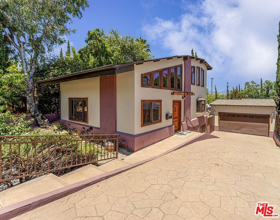 A benchmark of South Pasadena's environmental design. Thoughtfully customized and sustainably upgraded. This serene 2-bedroom, 2-bath residence complements an intentional lifestyle, thoughtfully aligned with ecological responsibility. The main floor features the kitchen and entertaining areas of the residence, flooded with natural light on all sides. Upstairs, the primary en-suite and second bedroom are gently brightened by skylights that invite in a calm, natural light. A custom balcony offers wide views of the San Gabriel Mountains, subtly connecting the indoors to the surrounding landscape. In the bathroom, a jet tub and meticulously detailed tilework showcase a subtle dedication to craftsmanship and purposeful design. Outside the drought-tolerant front yard with mature fruit trees and a bench offers a respite from evening strolls. The backyard features trellised grape vines, a spacious outdoor area for entertaining, and nightly soaks in the spa. A large 2-car garage with a GE electric vehicle charging station and attic space offers versatile storage options and room for expansion. Interior highlights include carbonized strand bamboo throughout the home and cork flooring in the kitchen. Lyptus and bamboo custom cabinetry, Richlite and recycled glass countertops, and American Clay zero-VOC wall finish. Milgard dual-pane low-e windows with lifetime warranty, recycled denim insulation, and solid wheat-core doors enhance comfort and efficiency. The bathrooms boast custom concrete finishes, while Ipe wood decks, stairs, and Class A fire-rated railings offer long-lasting durability and style. This home features a 5.39 kW Mission Solar system and an Owens Corning Cool Roof installed in 2023, which are fully paid and included with the sale. Walk your kids to award-winning schools, the Farmers Market, and all of the best that Mission Street and the South Pasadena community provide.