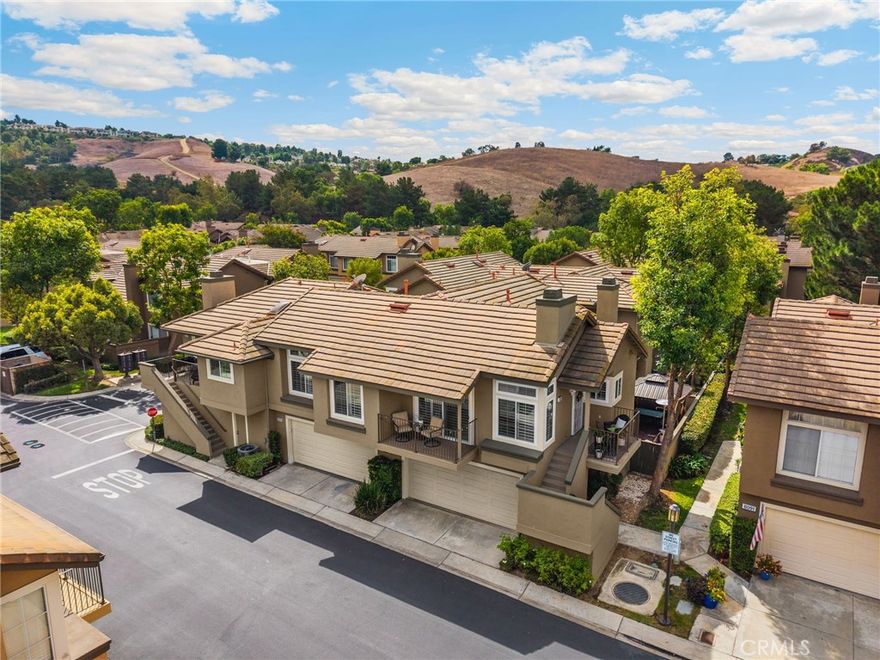 Beautifully Updated Condo in Desirable Anaheim Hills!  Welcome to this tastefully updated single-story, two-bedroom, two-bath condo situated above its own two-car garage in the sought-after Laurelwood community of Anaheim Hills. Positioned toward the back of the neighborhood, this home offers a peaceful setting away from street noise while still close to shopping, dining, and entertainment.  Step inside to discover a bright, open living space featuring laminate flooring throughout, newer carpet in the bedrooms, recessed lighting, and dual-pane windows for year-round comfort and efficiency. The inviting living room centers around a cozy fireplace accented with shiplap and a charming mantle, creating the perfect space to relax or entertain. This desirable floor plan—rarely available on the market—boasts two private balconies off the living room and has just been enhanced with a brand-new AC system. The renovated kitchen is a true showpiece, thoughtfully redesigned by the owner with custom storage solutions, crisp white cabinetry, quartz countertops, and a convenient breakfast bar. The spacious primary suite offers dual closets and a beautifully upgraded ensuite bathroom, while the secondary bedroom and bath provide ideal space for guests, family, or a home office.  The attached two-car garage includes ample built-in storage cabinets, and the home is conveniently located within walking distance to one of the two sparkling community pools. With abundant guest parking and a prime Anaheim Hills location, this move-in-ready home perfectly blends modern upgrades, thoughtful design, and everyday comfort.