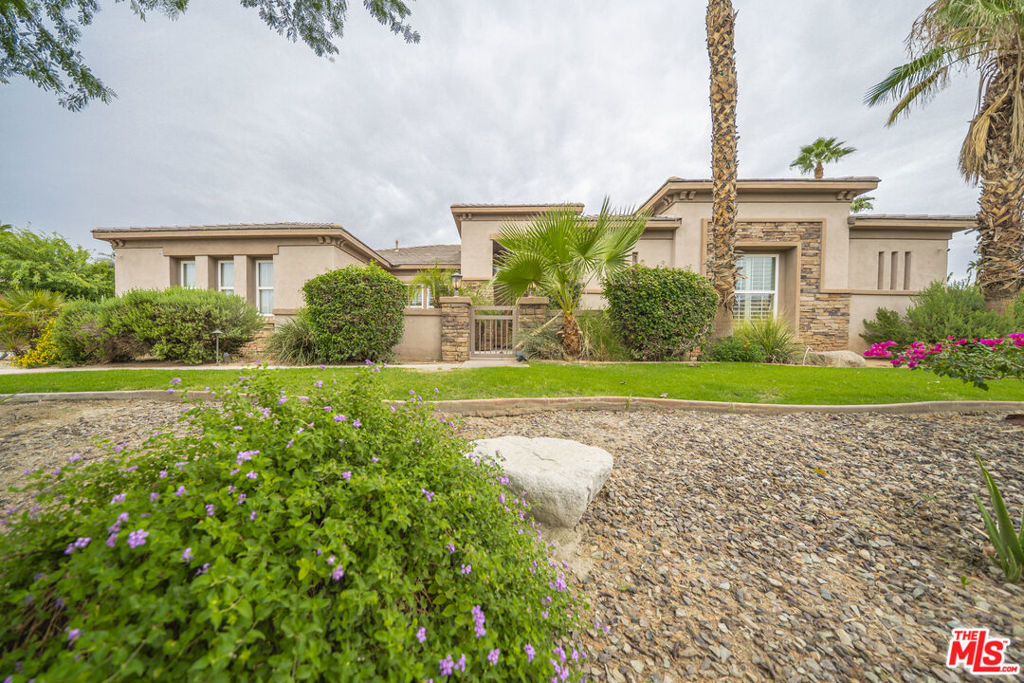 Discover refined desert living in this stunning 3,150 sq. ft. estate, ideally situated on a generous half-acre lot within the exclusive gated community of Desert River Estates.This 5-bedroom home, 3.5 baths and a seamless open floor plan accented by polished travertine flooring with custom inlays. The chef's kitchen is a true showpiece, showcasing granite slab countertops, built-in stainless steel appliances, a breakfast bar island, and abundant storage. The spacious primary suite is a private retreat, complete with dual vanities featuring travertine counters, a jetted soaking tub, a walk-in shower with bench seating, and his-and-her walk-in closets.Perfect for indoor-outdoor entertaining, the great room opens to a covered loggia with a retractable awning and sun shade, leading to a resort-style backyard. Enjoy a sparkling saltwater pool and spa with dual spillways, an outdoor shower, built-in BBQ, and multiple lounging areas ideal for gatherings or quiet relaxation. The 3-car garage currently transformed into a game room and entertainment space adds flexibility for lifestyle needs. Located just minutes from world-class golf courses, shopping, dining, and iconic Coachella Valley entertainment venues, this home blends privacy, elegance, and convenience. The property is perfect whether one is looking for primary residence, second home or monthly or seasonal vacation rental.