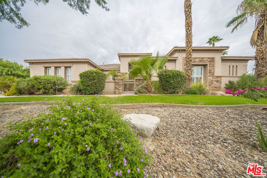 Discover refined desert living in this stunning 3,150 sq. ft. estate, ideally situated on a generous half-acre lot within the exclusive gated community of Desert River Estates.This 5-bedroom home,  3.5 baths and a seamless open floor plan accented by polished travertine flooring with custom inlays. The chef's kitchen is a true showpiece, showcasing granite slab countertops, built-in stainless steel appliances, a breakfast bar island, and abundant storage. The spacious primary suite is a private retreat, complete with dual vanities featuring travertine counters, a jetted soaking tub, a walk-in shower with bench seating, and his-and-her walk-in closets.Perfect for indoor-outdoor entertaining, the great room opens to a covered loggia with a retractable awning and sun shade, leading to a resort-style backyard. Enjoy a sparkling saltwater pool and spa with dual spillways, an outdoor shower, built-in BBQ, and multiple lounging areas ideal for gatherings or quiet relaxation. The 3-car garage currently transformed into a game room and entertainment space adds flexibility for lifestyle needs. Located just minutes from world-class golf courses, shopping, dining, and iconic Coachella Valley entertainment venues, this home blends privacy, elegance, and convenience. The property is perfect whether one is looking for primary residence, second home or monthly or seasonal vacation rental.