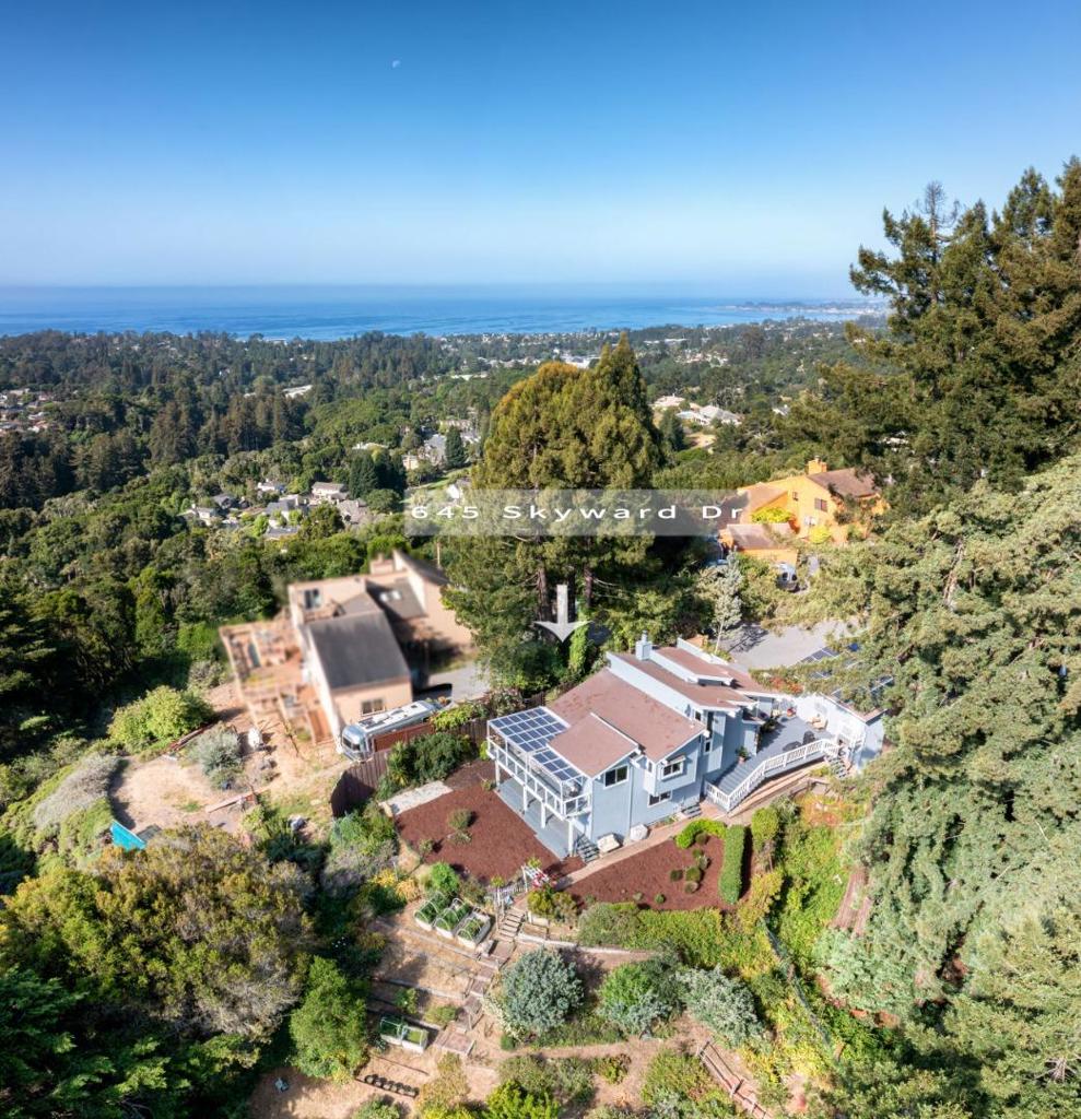 MAGICAL OASIS! Tucked just 5 minutes from the vibrant new Aptos Village, this beautifully styled 3-bedroom, 2.5-bath home offers a serene retreat with ocean and mountain views. Soaring ceilings and abundant natural light create an airy feel throughout. The open-concept kitchen and dining area flow seamlessly to a private patio, perfect for entertaining or relaxing al fresco. A spacious living room with vaulted ceilings leads to a loft-style family room, complete with views of the bay. Lush, thoughtfully designed gardens surround the home, with terraced hillsides featuring drought-tolerant plantings, a rose garden, and a variety of mature fruit trees. Nestled beneath a majestic redwood grove, a tranquil sitting area invites quiet mornings with nature. Upgrades include new furnace, gas lines, generator system, electric panel, fridge & dishwasher, light fixtures, interior and exterior paint, propane tank, reverse osmosis in kitchen, high-end gutter guards, fence around house, soft water system. Solar system is owned and in place. Two-car garage and generous parking space for an RV, boat, or guests. This property is more than a home, it's a lifestyle you'll never want to leave.