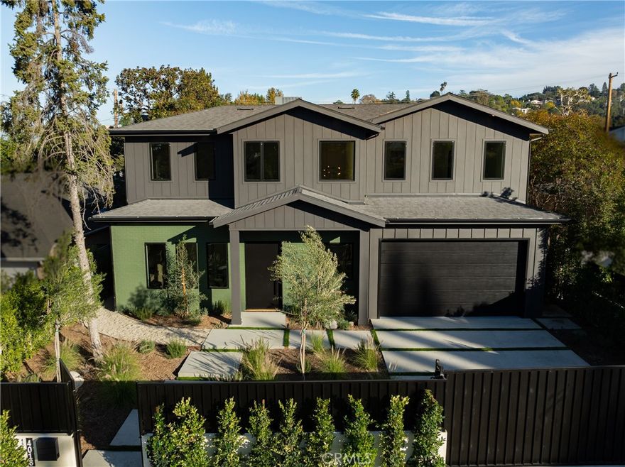 A striking statement of modern luxury, this newly constructed gated estate situated in the heart of Studio City offers a 5-bed, 6-bath main residence and 1-bed, 1-bath ADU. Inside, an expansive open floor plan unfolds beneath lofty ceilings and walls of glass that flood the home with natural light, making every room feel open, bright and inviting. The chef’s kitchen is a showpiece, anchored by a massive waterfall island and outfitted with top-of-the-line appliances, a hidden walk-in pantry, and sleek custom cabinetry. The adjoining living room features an oversized sliding glass door that opens to create a seamless transition for indoor-outdoor living. An elegant formal dining room with built-in wine storage elevates everyday meals and transforms special occasions into unforgettable gatherings. On the main level you’ll also find a state-of-the-art home theater, ensuite bedroom, stylish powder room and direct access to the two-car garage. Upstairs, four additional ensuite bedrooms offer comfort and privacy, along with a dedicated laundry room for convenience. The primary suite is a sanctuary unto itself, complete with a large covered balcony, dual walk-in closets and a spa-inspired bathroom featuring a deep soaking tub, oversized rainfall shower and double vanity. Designed for California living at its finest, the entertainer's backyard is highlighted by a built-in BBQ and sparkling pool/spa that invites year-round enjoyment. The attached ADU boasts a private entrance, spacious living room with a full kitchen, a bedroom and bathroom, offering exceptional versatility for guests, extended family or as additional living space. Fully integrated with a Control4 smart system, the home allows seamless control of the speakers, lighting, climate and a comprehensive security system with cameras. Located in Coldwater Canyon, this excellent South of the Boulevard location is within the sought-after Dixie Canyon School District and allows for easy access to both the Valley and Westside.