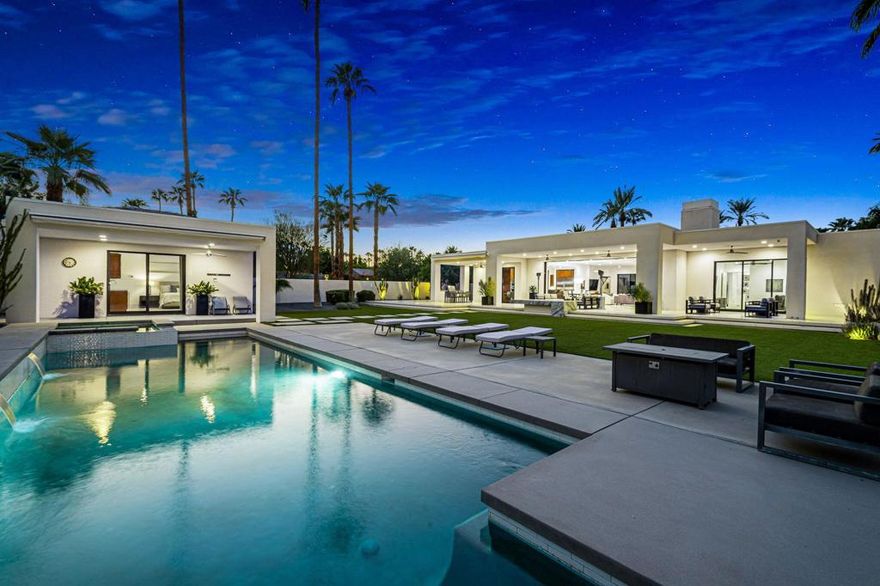Welcome to 40700 Desert Creek, a striking contemporary estate in the exclusive gated community of Mission Ranch, Rancho Mirage. Rebuilt from the studs and meticulously maintained, this residence blends crisp architectural lines with warm details that embrace desert living. Set on a sprawling 36,590 square foot ultra-private corner lot with 4,591 square feet of interior space, the home offers 4 bedrooms, 4.5 baths, a detached guest house, and expansive entertaining areas designed for seamless indoor-outdoor living. The main living area showcases soaring vaulted ceilings, abundant skylights, and floor-to-ceiling glass doors, connecting the interiors to the outdoor living spaces. A dramatic raised hearth fireplace with custom built-ins anchors the great room, while Hunter Douglas automated blinds, custom window treatments, and smart-home technology place comfort at your fingertips. The chef's kitchen is both beautiful and functional, featuring quartz counters, an oversized island with seating, SubZero refrigerator, commercial-grade stainless appliances, a wine fridge, and a sleek wet bar for effortless entertaining. The primary suite is a private sanctuary, complete with living area, spa-inspired bath with soaking tub and walk-in shower, dual custom closets, and direct access to the poolside terraces. Outdoor living is elevated with expansive patios, a covered outdoor kitchen, and an 11-foot fire feature overlooking the sparkling pool and spa. The detached guest house, thoughtfully positioned near the pool, offers a full bath and morning bar perfect for visitors or extended stays. The grounds are enhanced by citrus trees, low-maintenance desert landscaping with architectural lighting, and a large motor court with a three-car garage. Every detail of this property reflects careful design and pride of ownership, from ultra high-end finishes and fixtures to smart-home automation throughout. Centrally located near world-class dining, shopping, and golf, this estate offers a rare combination of privacy, sophistication, and modern desert lifestyle. An architectural gem designed for both everyday living and unforgettable gatherings.