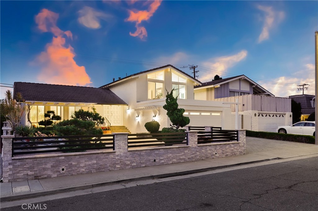 This beautifully updated 4-bedroom, 3-bathroom home in the Theme Homes community of Huntington Beach offers an ideal blend of style, comfort, and coastal convenience. Completely refreshed since the current owners moved in, the residence features fresh interior paint, new flooring throughout, remodeled bathrooms, and recessed lighting throughout. The downstairs bedroom and full bath make for a convenient layout. The gourmet kitchen comes equipped with updated cabinets, all included appliances, travertine floors, and a walk-in pantry. Other standout features include high ceilings, bay windows in the formal dining room, and dual-pane windows. Outside, the graceful front yard is enhanced by luxe stonework, bonsai garden, and decorative iron fencing atop stone walls, while the backyard showcases stone pavers and steps, elevated planter walls, and mature fruit trees. Additional highlights include a spacious two-car garage with built-in storage and attic access, RV parking, and a designated laundry room. Upstairs, you will find two guest bedrooms and the light-filled primary suite boasts soaring ceilings and its own full bathroom. Located just minutes from the sand, this home offers easy access to Meadowlark Golf Course at the edge of the neighborhood, top-rated Huntington Beach schools. With a short drive to surf, beaches, restaurants, shops, and freeways, this home offers the perfect Southern California lifestyle.