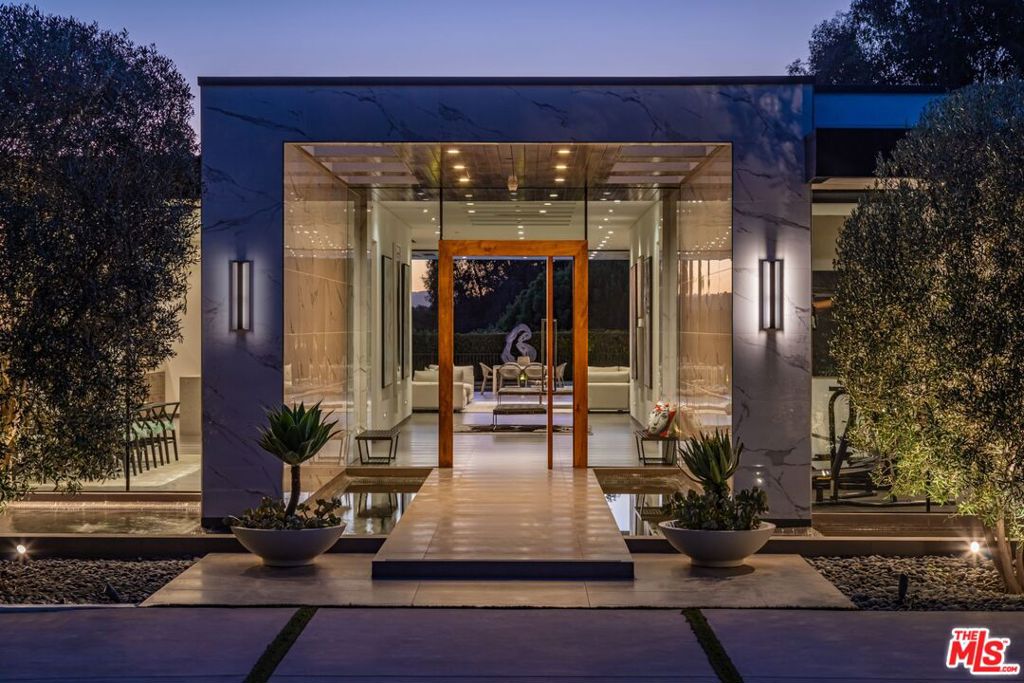 A modern masterpiece on a sprawling 37,000 SF prime lot in the exclusive Trousdale Estates. Tucked away off Loma Vista Drive, behind a gated 200-foot-long gated driveway, this property ensures complete privacy while offering breathtaking canyon views. Once the site of Dean Martin's home, this newly constructed estate, completed in 2017, embodies luxury and glamour. With over 10,000 SF of living space, the estate features 12-foot ceilings and the latest and greatest amenities, including Crestron home automation system. The floating entrance leads to a light-filled gallery-style foyer that is perfect for displaying your art collection. The expansive great room includes a living room, family room, and bar, all enhanced by motorized Fleetwood doors opening to a remarkable outdoor space for seamless indoor/outdoor living. The outdoor oasis features a large patio, fireplace, a pool, an outdoor kitchen with a 48" BBQ range, and lush canyon views. The formal dining room boasts a wine display for 300 bottles, adjacent to a custom kitchen with Miele appliances. The luxurious primary suite offers a fireplace, dual walk-in closets, and a spa-like bathroom. Four additional bedroom suites feature private patios, and amenities include a theater, gym, and spa. With a motor court for 20+ cars and a three-car garage, this estate offers an unparalleled living experience in an exclusive locale. This Trousdale estate represents the pinnacle of luxury living, offering an unmatched blend of privacy, elegance, and breathtaking views in one of Los Angeles' most exclusive neighborhoods.